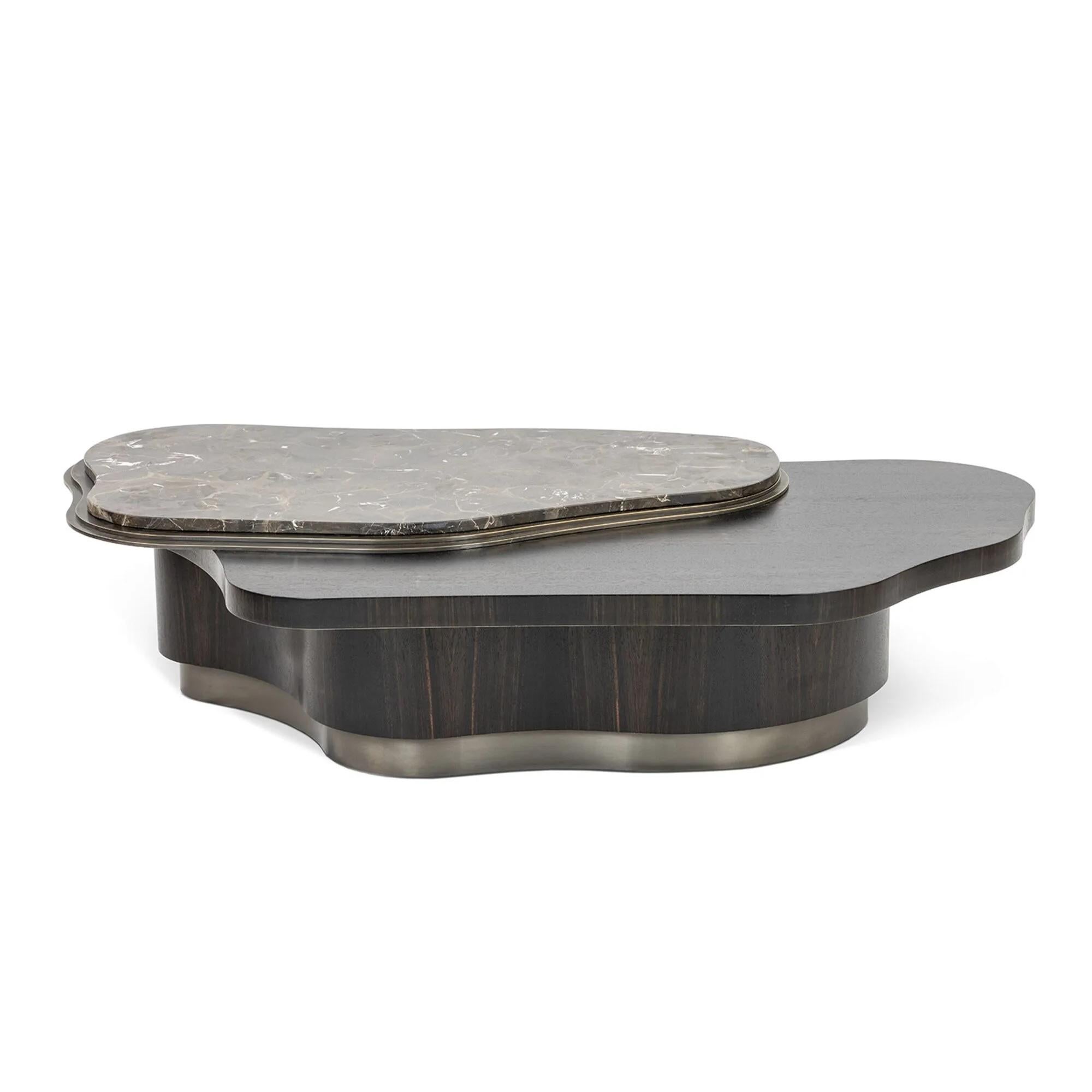 Cette table basse dégage une allure puissante avec ses plateaux en laiton superposés, qui prennent une forme organique servant de base au saisissant plateau en marbre. La structure de la base suit harmonieusement le contour des plateaux, ce qui