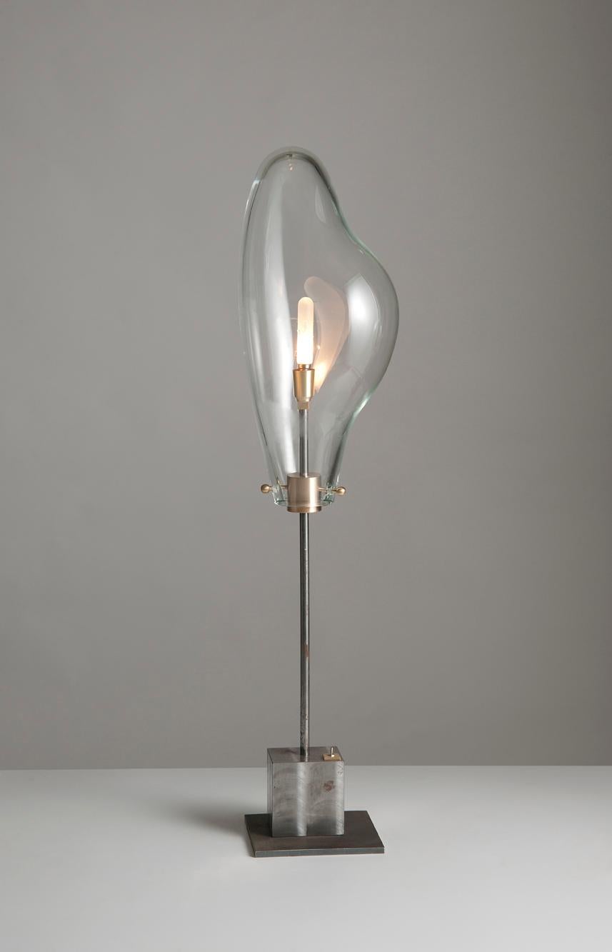 Amorphous liquid lamp by Sema Topaloglu
Dimensions: 17 x 31 x 99.7 cm.
Materials: iron, handblown glass.

Sema Topaloglu is known for her dedication to materials, craftsmanship and a unique aesthetic vision. The tactile and visual relations