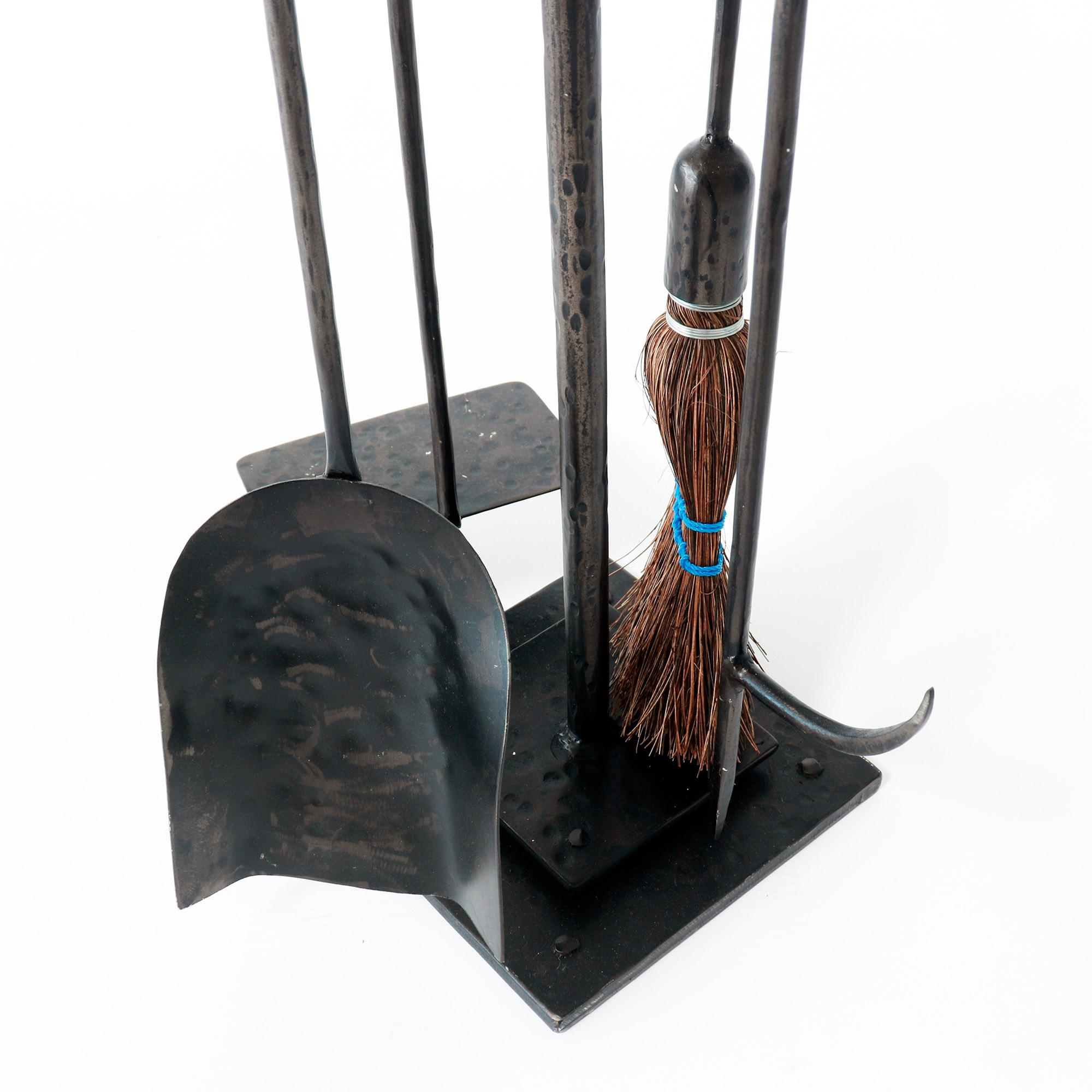 This hand forged iron fireplace tool set includes a poker, brush, shovel, and log pull. The blackened metal tower adds a touch of class to your fireplace display. 

Add style and function to your fireplace with this high-quality, hand-forged iron