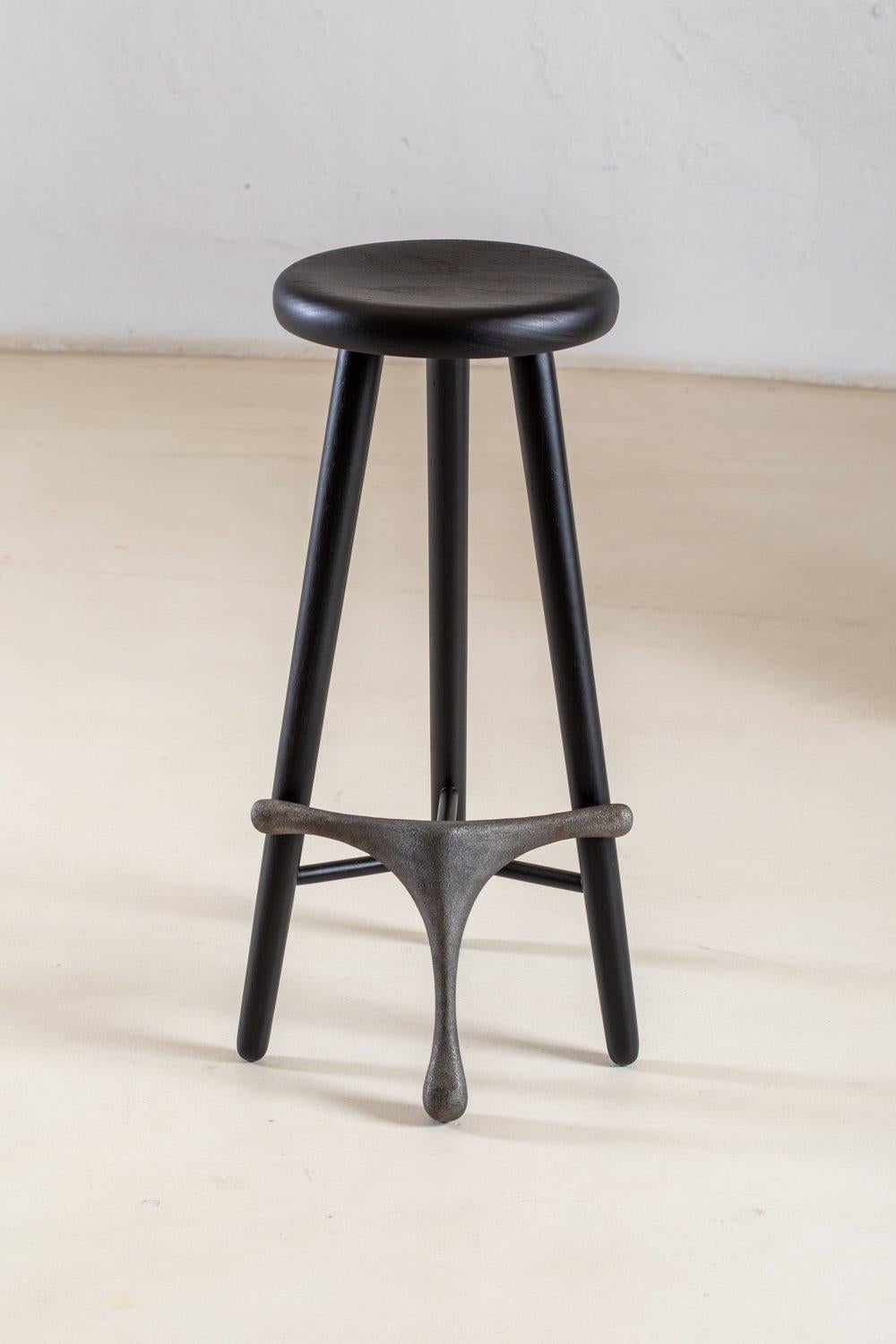 Amparo Jequitibá and Iron Stool by Alva Design
Materials: blackened solid wood (Jequitibá) and iron.
Dimensions: W 37 x D 48 x H 63 cm.

Available in different wood options (Braúna or Freijó solid wood) and footrest options (solid wood, iron or