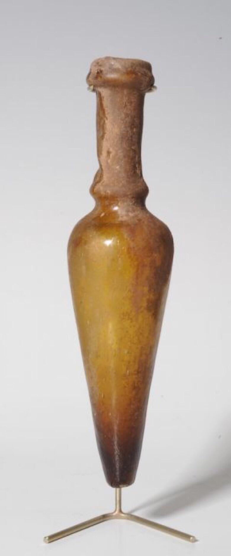 Amphora shaped glass bottle
Eastern Mediterranean, Roman Period, circa 4th century AD.
Amber-colored glass.
Blown Amphora shaped perfume bottle of a rare type.
Condition: Partially sintered, intact.