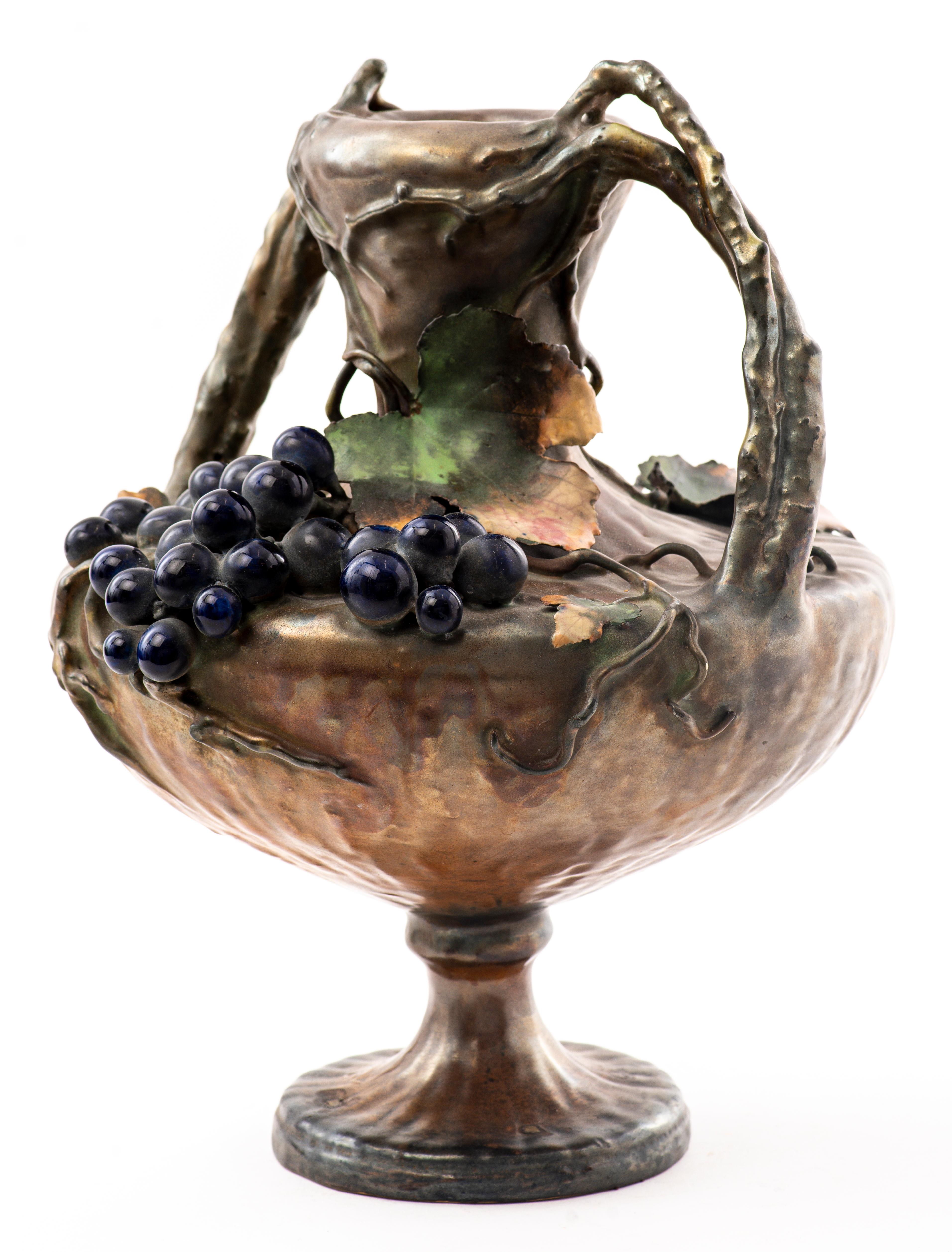 Amphora Austrian Art Nouveau semi-iridescent ceramic two-handled vase decorated with hanging grape cluster and vines and leaves. Marked and numbered on bottom.
Dimensions: 14