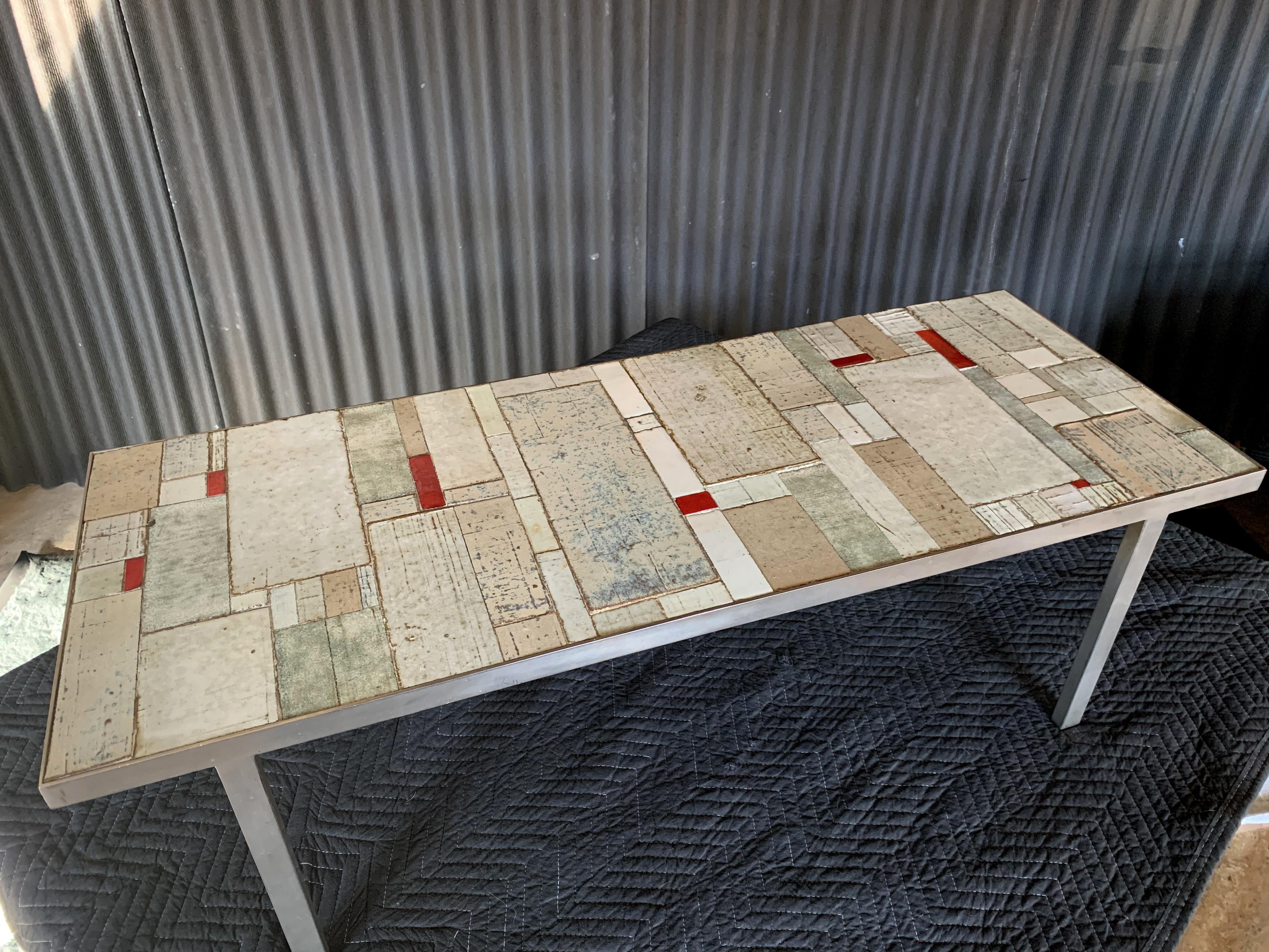 Beautiful and unique coffee table by Belgian ceramicist, Rogier Vandeweghe.
Amphora Stuidio, circa 1960.
Inlay ceramic pieces are set inside a steel frame.
Very good condition with no broken or missing pieces.

Measures: 48 x 18 x 15.5h.
 