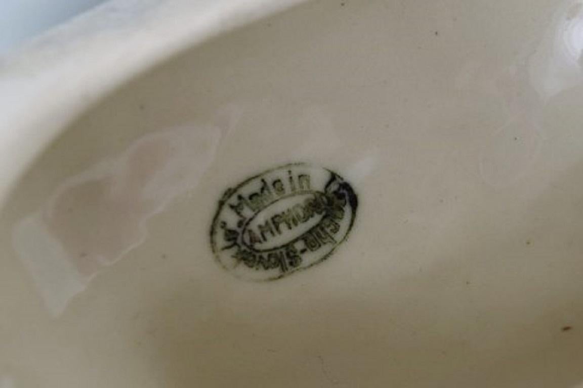 Amphora Czechoslovakia, Figurilla de porcelana pintada a mano de leona sobre roca mediados del siglo XX en venta