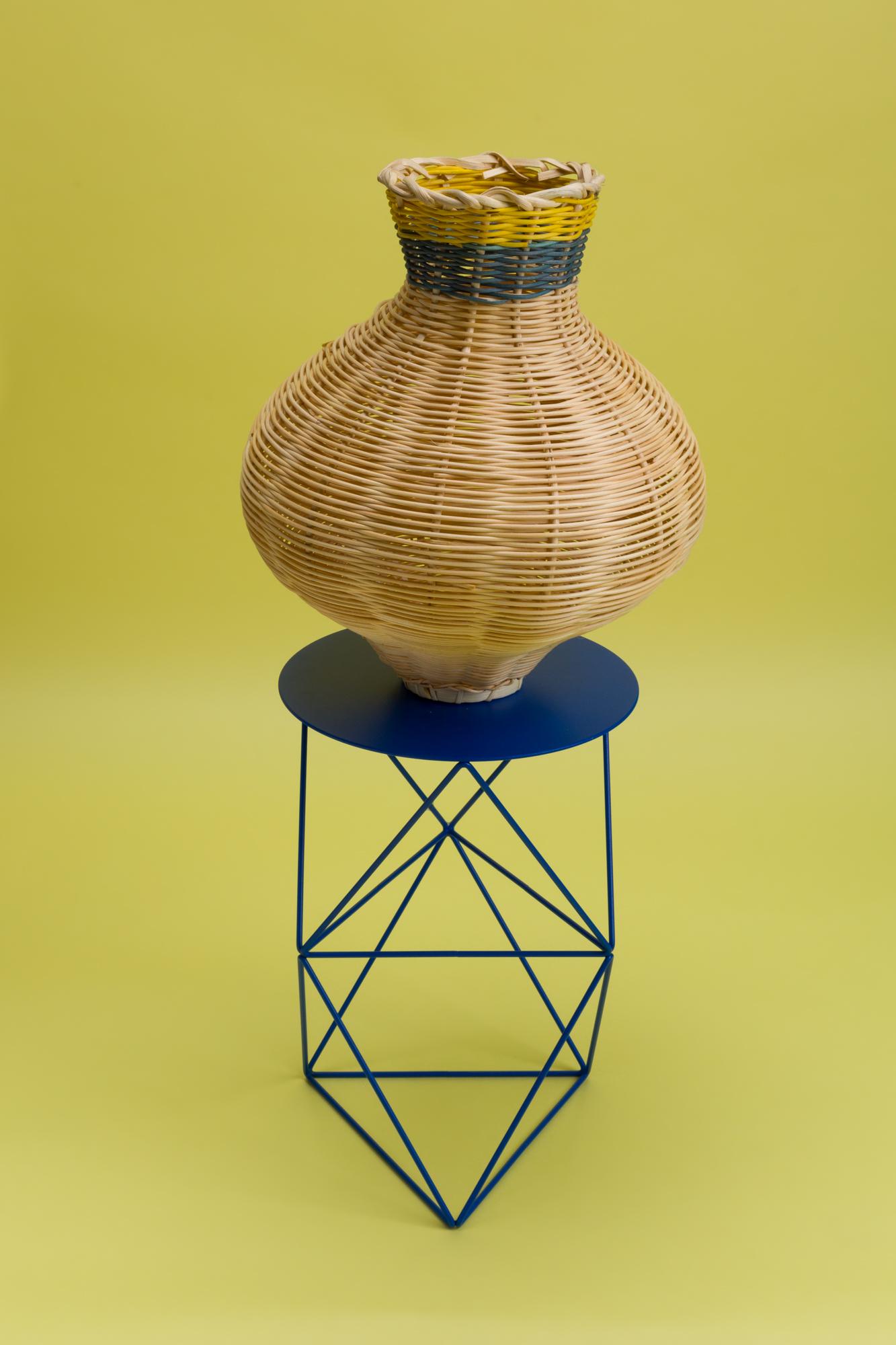 The Amphora Vase Woven in Natural + Denim + Lemon is a one-of-a-kind objet d’art, hand dyed and woven with reed in our Chicago studio. 

Inspired by forms in ancient Greek ceramics, the material language of this vessel brings together the rich