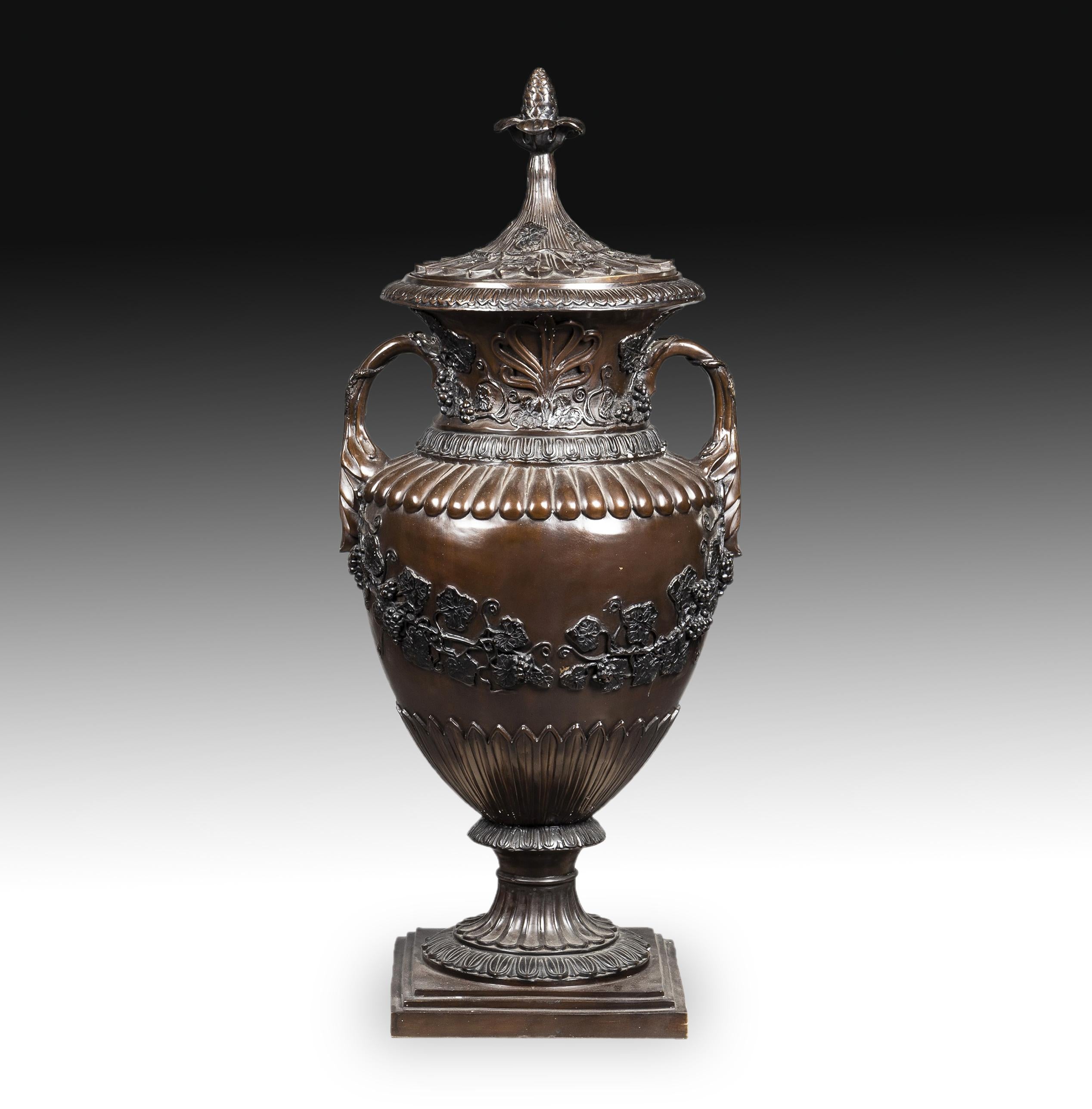 On a staggered square base, the amphora is raised. The foot presents gallons, which are repeated in the body of the container; in it there are branches and grapes as well as palmettes in the neck and two handles made with plant motifs. This same