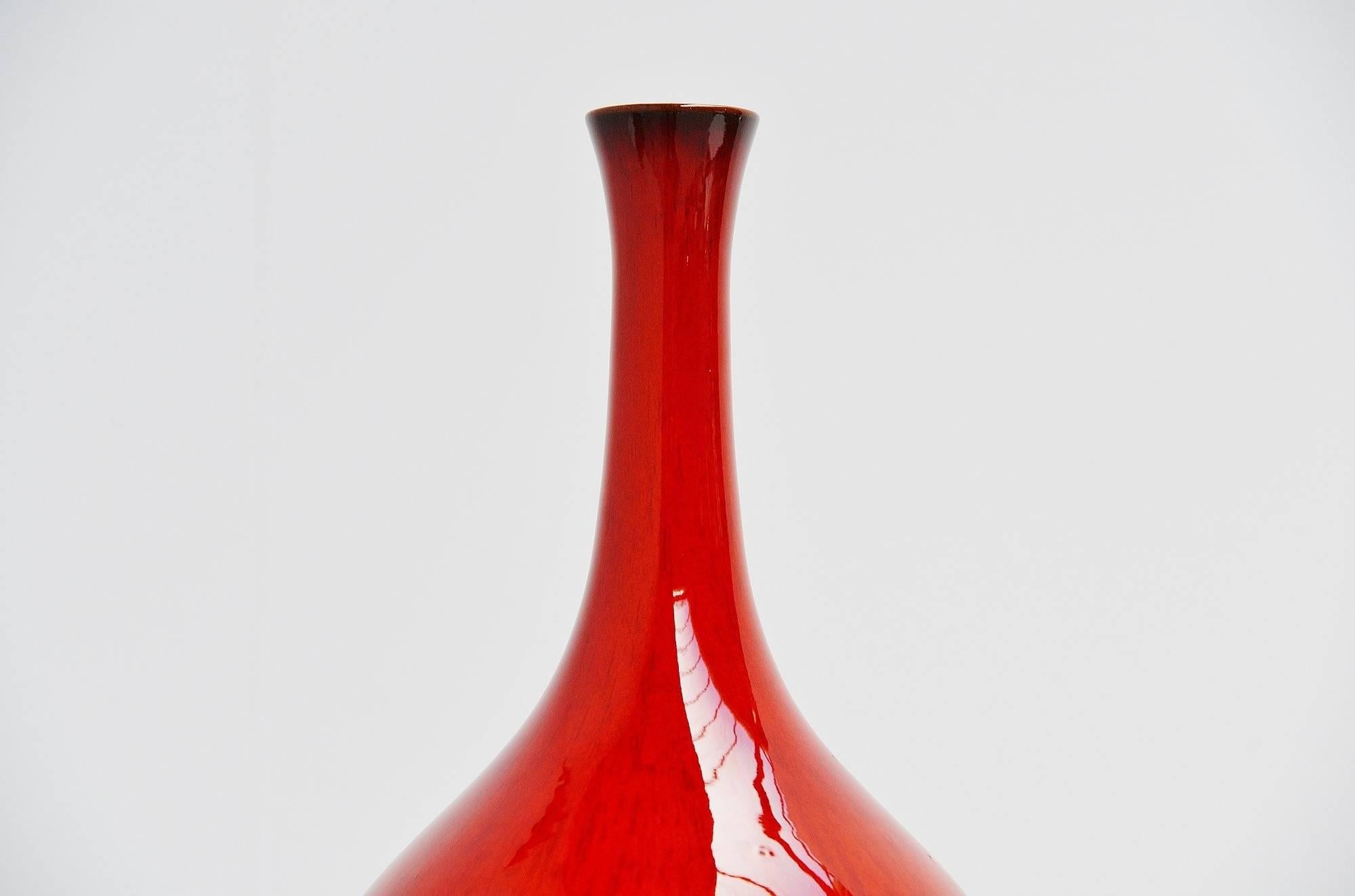 Highly decorative and nice ceramic vase designed by Rogier Vandeweghe and manufactured by Amphora, Belgium, 1963. This vase has an amazing shape and red glaze and would look highly decorative in any modern home or interior. The vase is signed with
