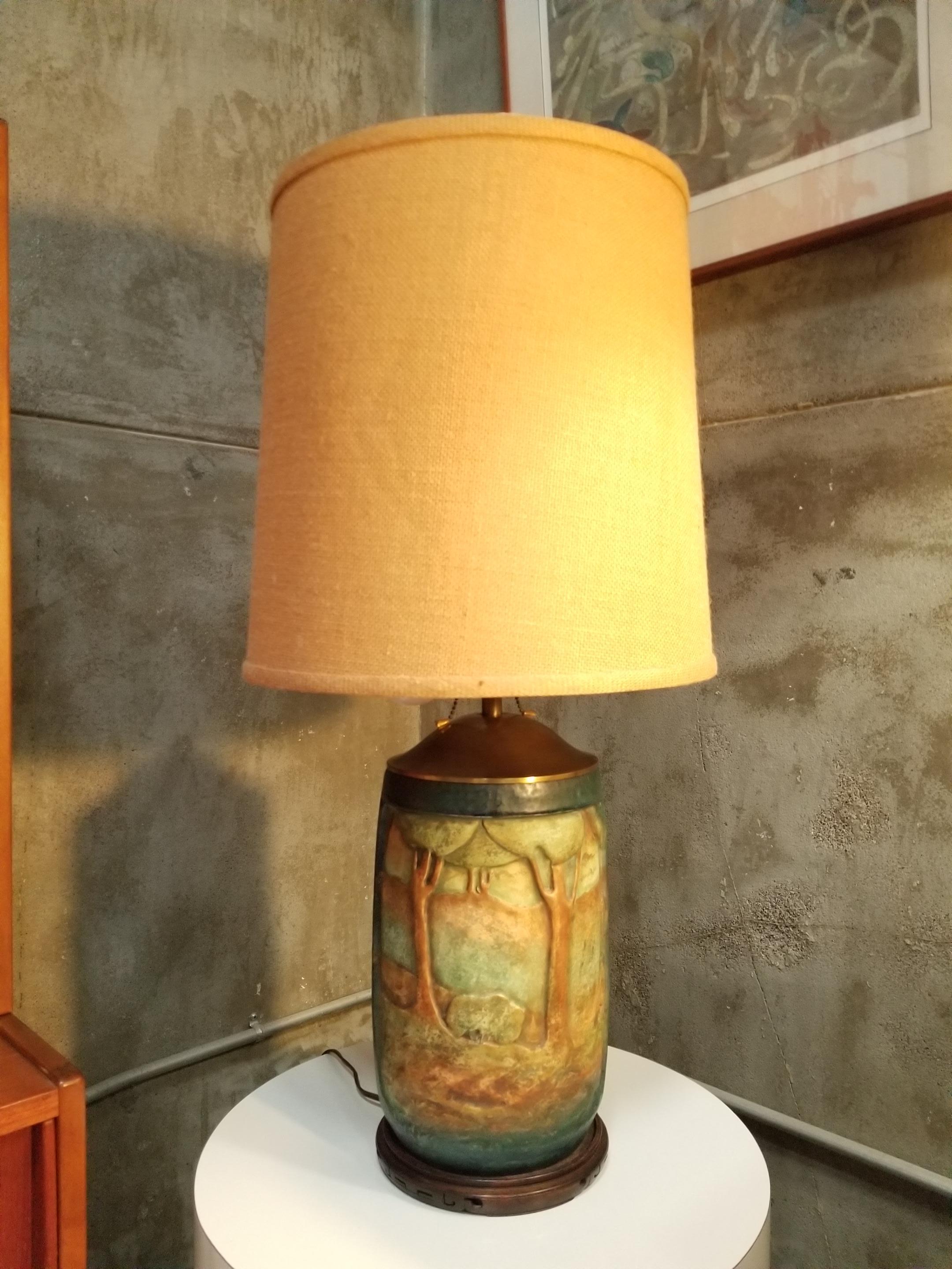Early 20th century Arts & Crafts era ceramic poly-chrome table lamp by Amphora. Two sided decoration depicting The Harvest on one side and a forest scene verso. Matt glaze with soft, organic color palette. Ceramic base only stands 12