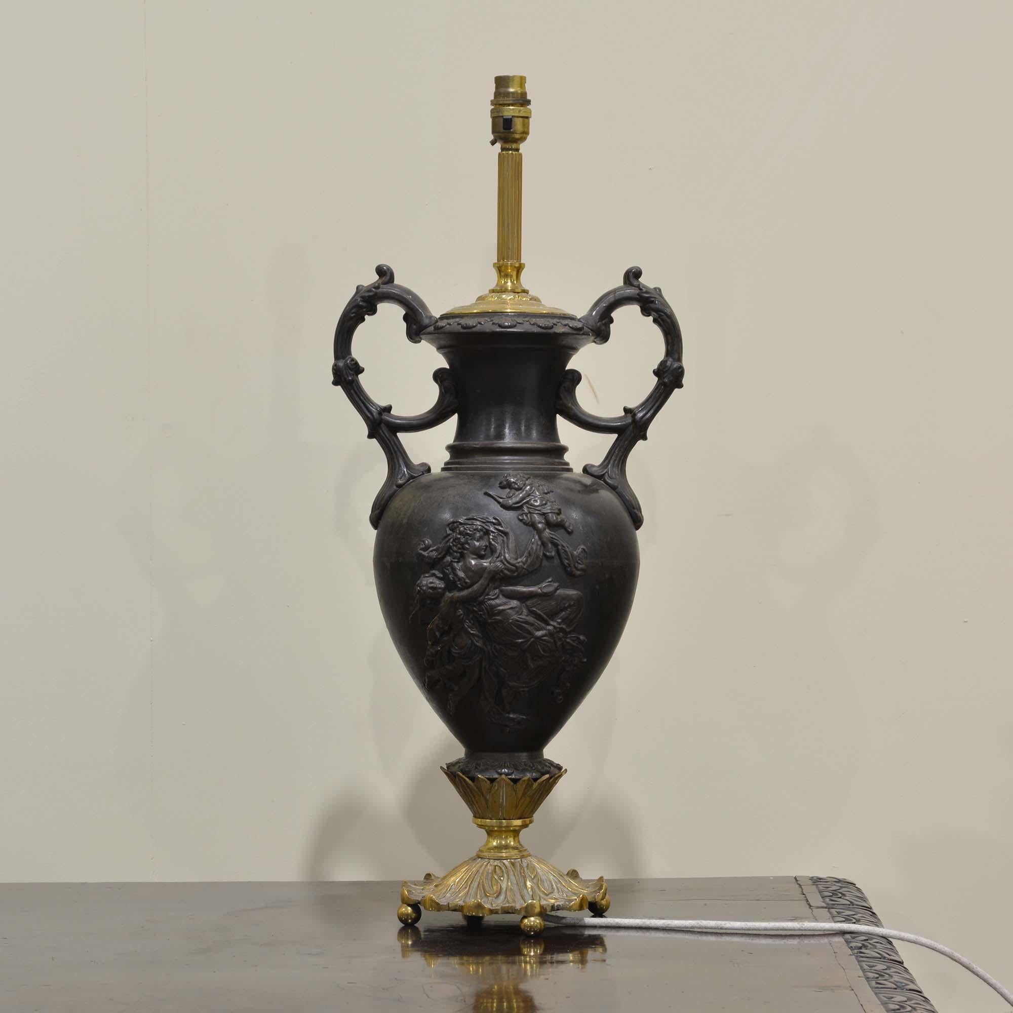 Amphora urn lamp
A twin handled urn depicting classical scenes in relief, to one side a maiden with cupid and putti, to the other the figure of confidence leading the way to the future carrying a torch.  Ceramic urn glazed as bronze.  With well cast