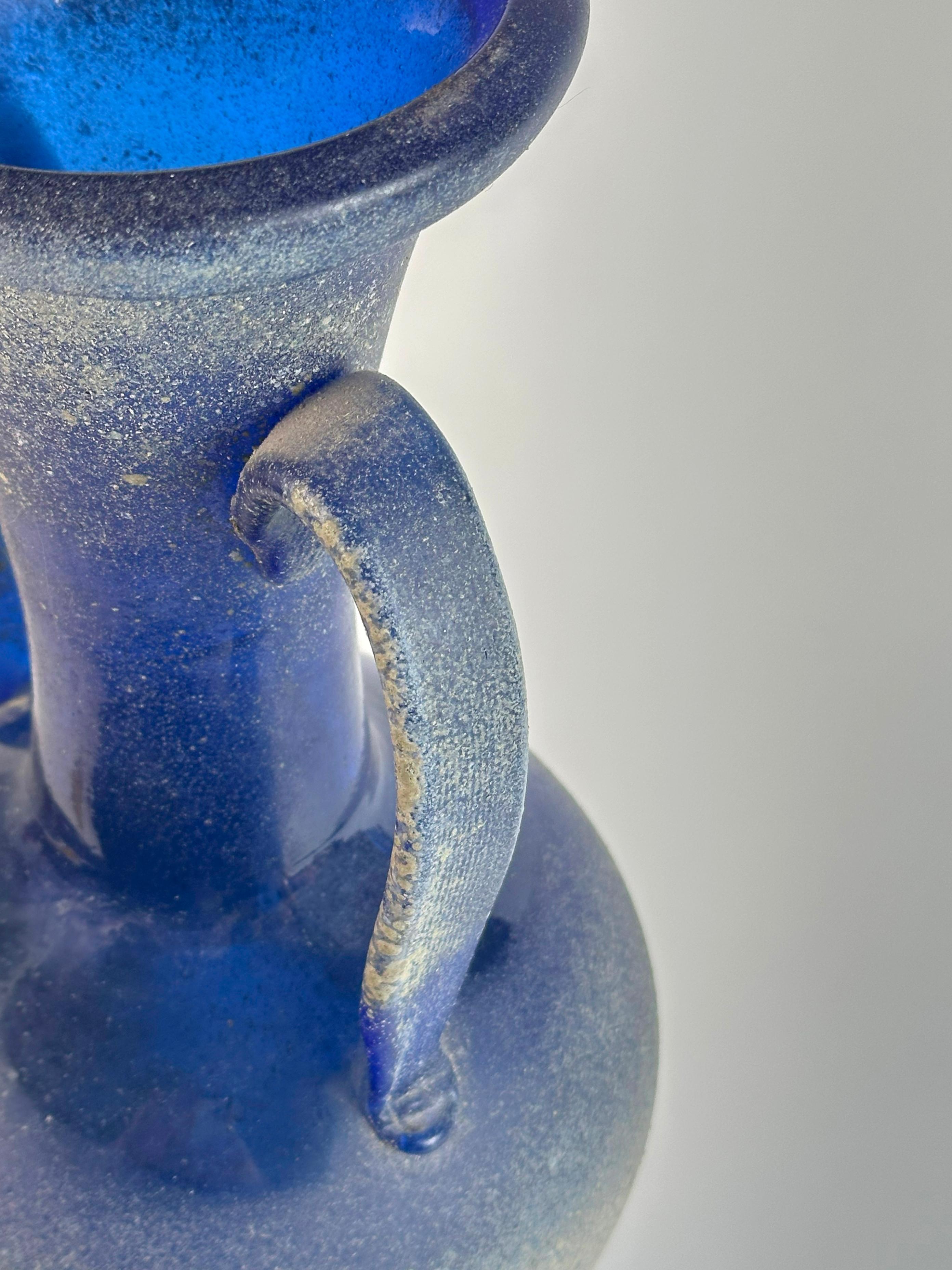 Un vaso a forma di anfora straordinariamente scultoreo di Seguso Vetri d'Arte, realizzato in Italia negli anni Settanta. Realizzato in vetro scavo blu cobalto riccamente pigmentato, il vaso trae il suo vocabolario estetico dall'antichità,