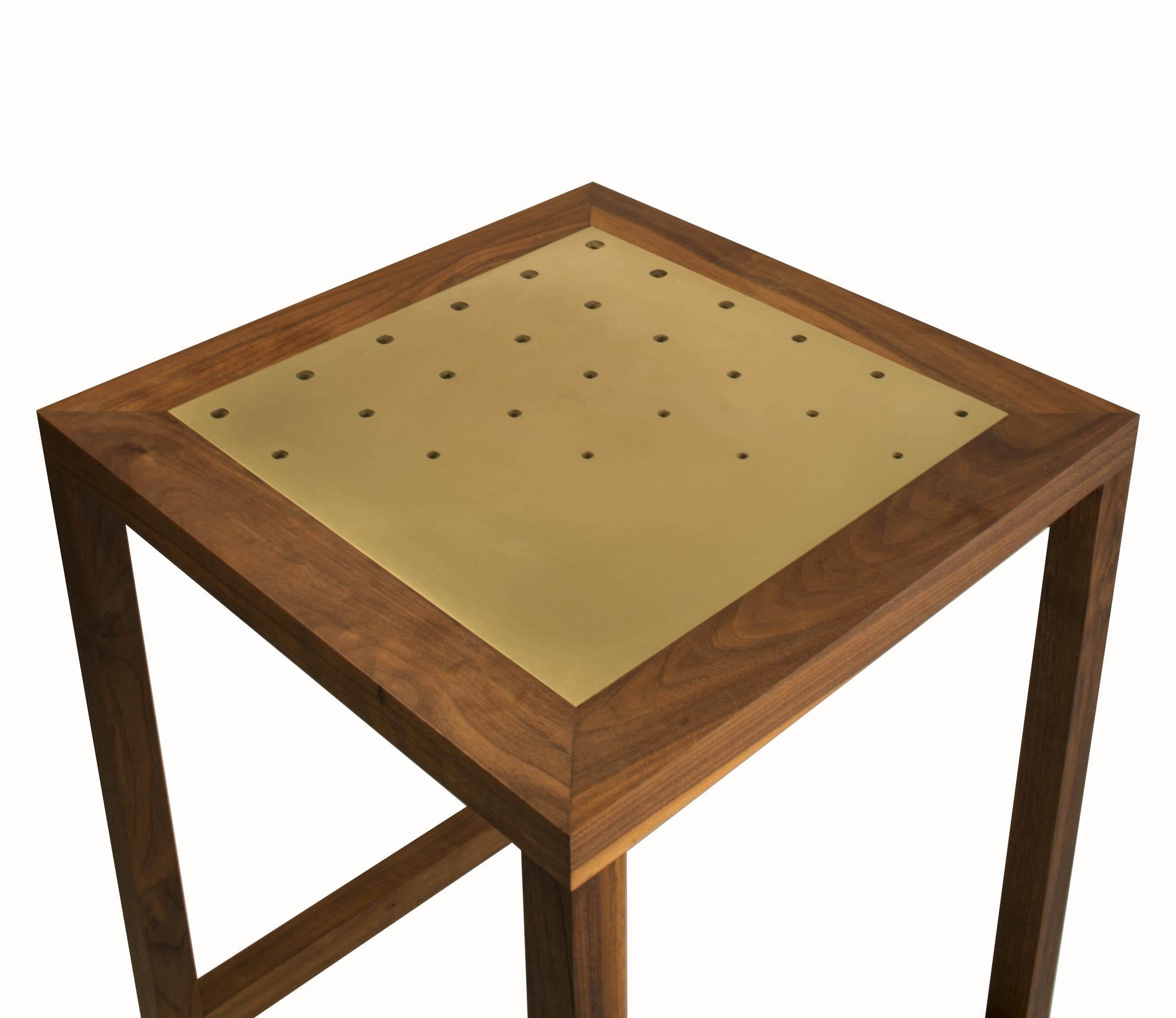 The Amplitude end table features a solid walnut frame inlaid with a brass panel. The clean geometric lines and gradating hole pattern produce a simple yet dynamic form, well suited to highlight the natural beauty of the materials. Please see the