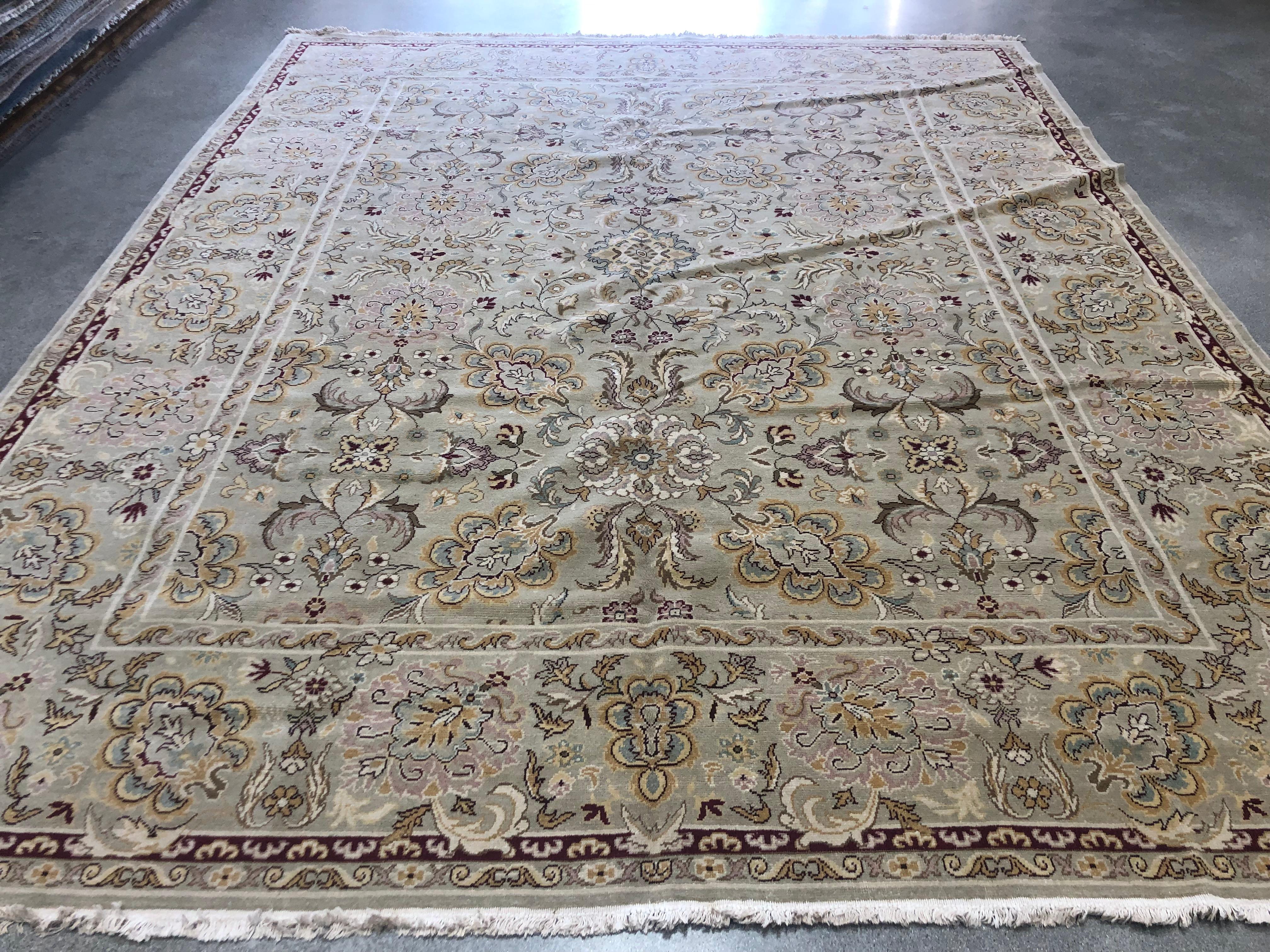 A beautiful bouquet of blue, yellow, pink, teal, red, green, cream and gold flowers bloom against a beige background in this Amritsar style floral rug. Hand knotted wool.