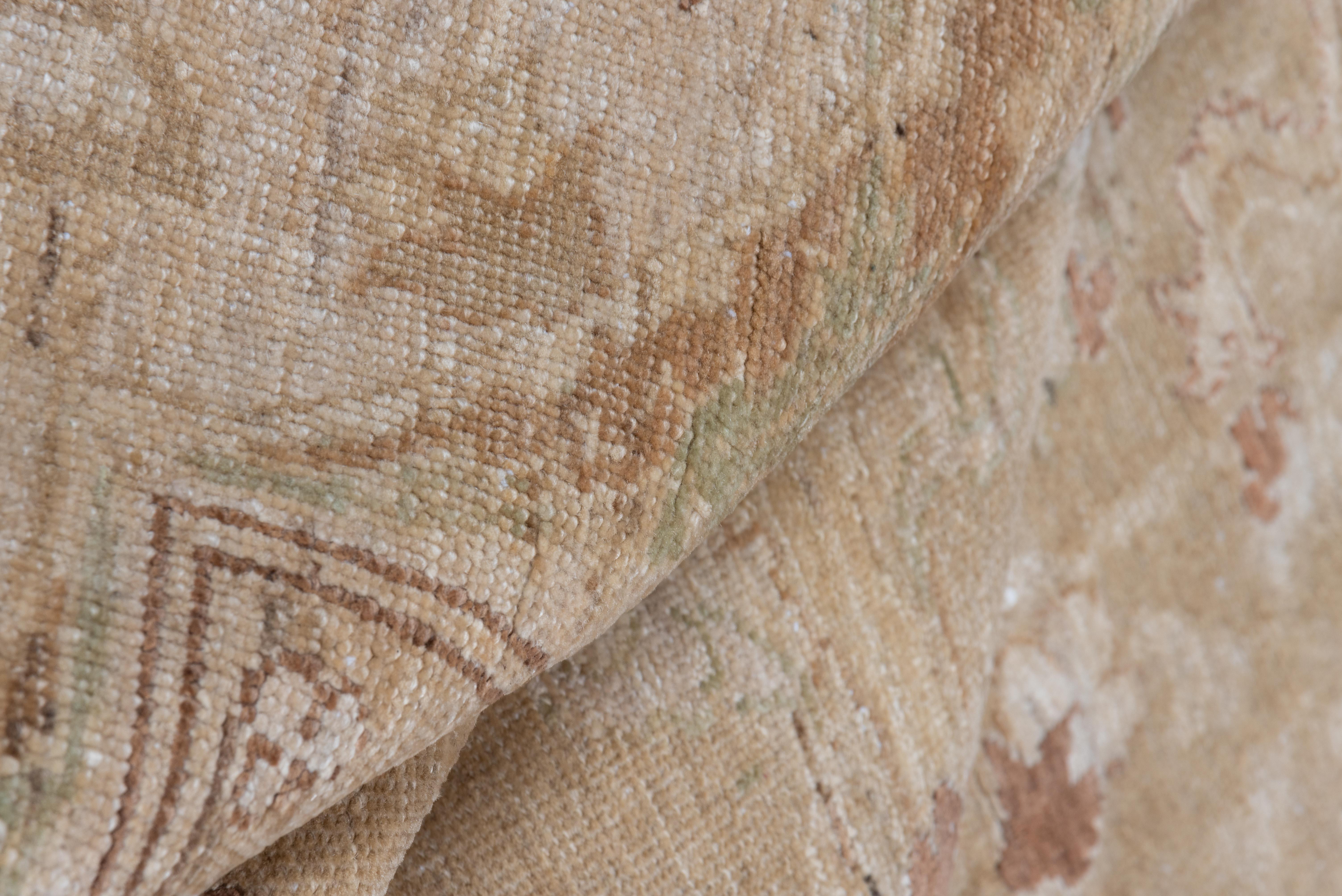 Dieser Amritzar-Teppich im Vintage-Stil zeichnet sich durch eine elegant gezeichnete Komposition aus, bei der weiche Taupe- und Sandtöne den Hintergrund für ein sich schlängelndes Blumen- und Rankenmuster in Elfenbein-, staubigen Mauve- und