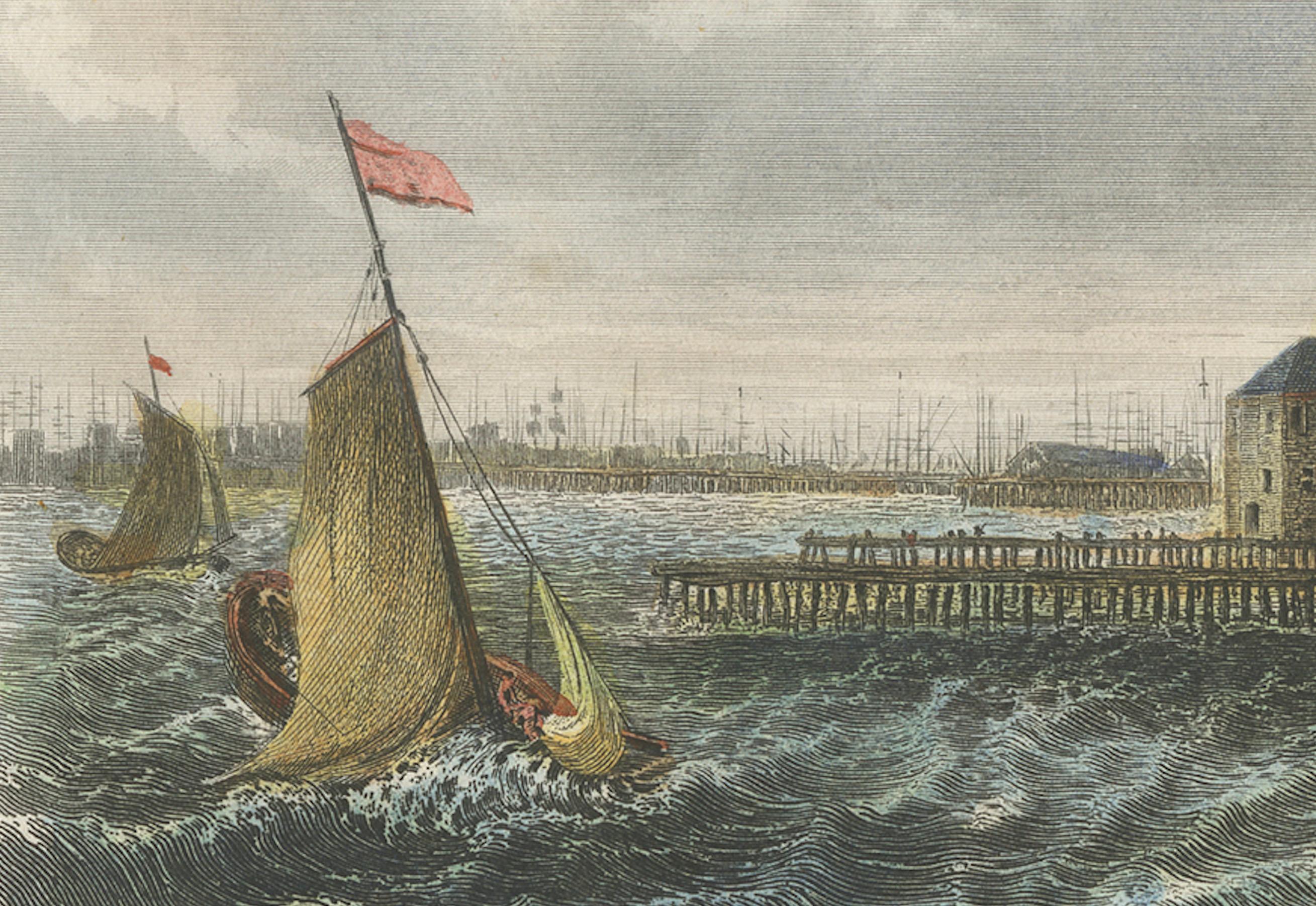 This hand-colored engraving depicts a maritime scene in Amsterdam, capital of The Netherlands. The view shows the bustling waterfront, with sailboats navigating through choppy waters near the city’s piers. To the right of the image are the classic