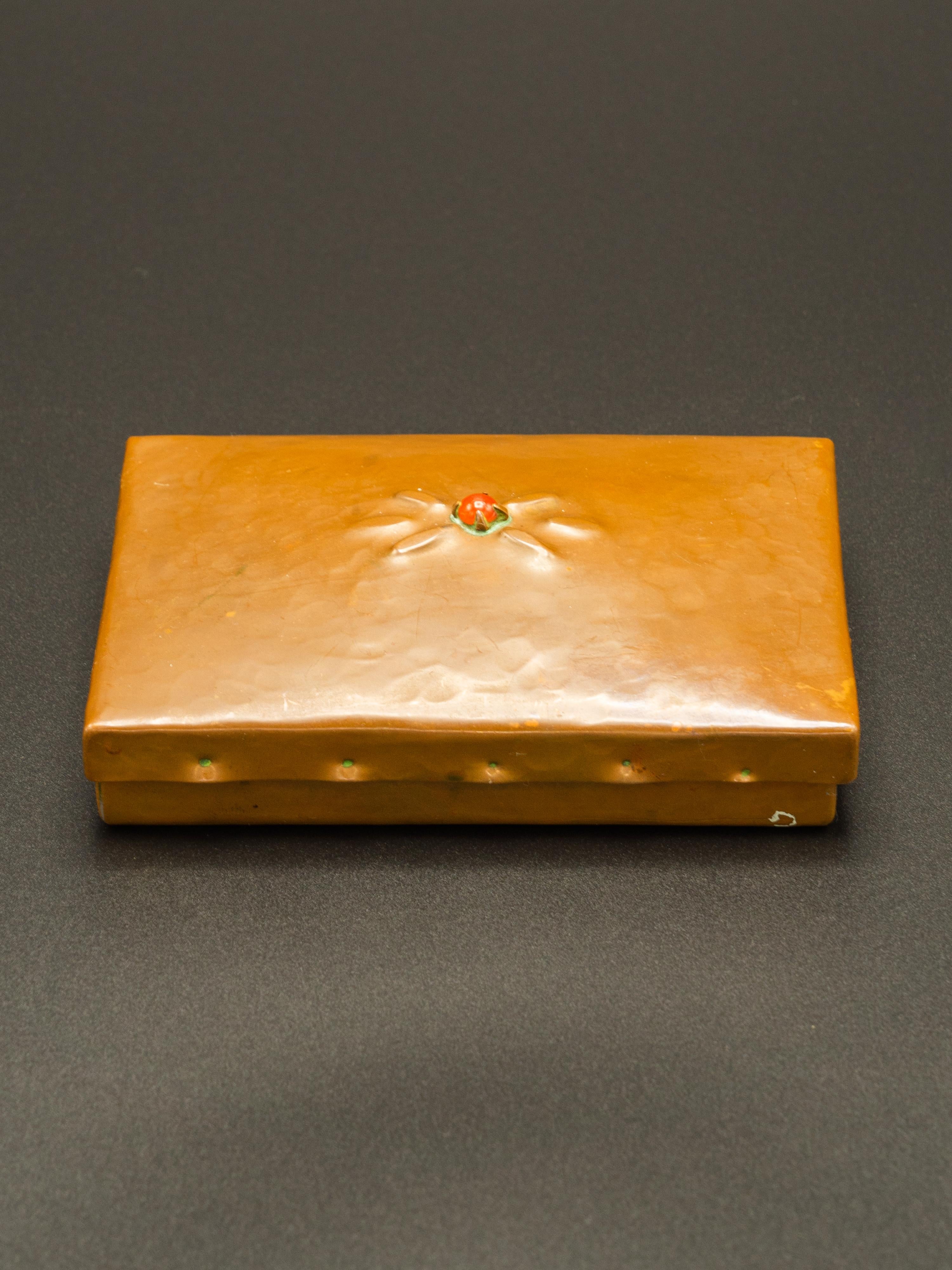 Cette tabatière en cuivre, fabriquée dans le style de l'école d'Amsterdam, est un exemple caractéristique de l'art fonctionnel du début du XXe siècle. La finition en cuivre martelé, aujourd'hui rehaussée d'une riche patine, confère à la boîte une