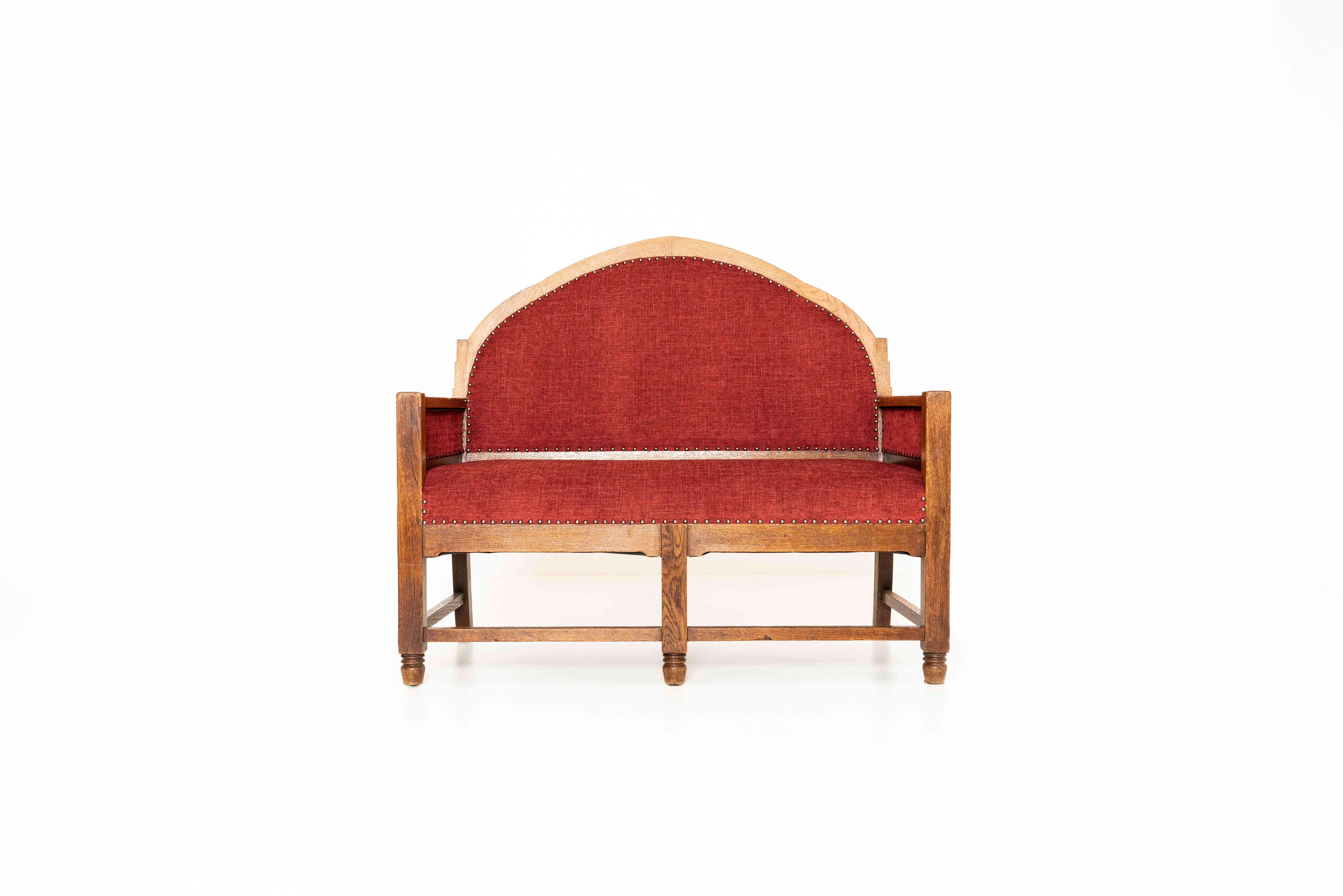 Charming Amsterdam School hall bench or sofa. This bench has a minimalistic and functional design with an oak wooden base. The wooden structure has nice details which can be seen on the feet of the bench. It has been completely re-upholstered in an