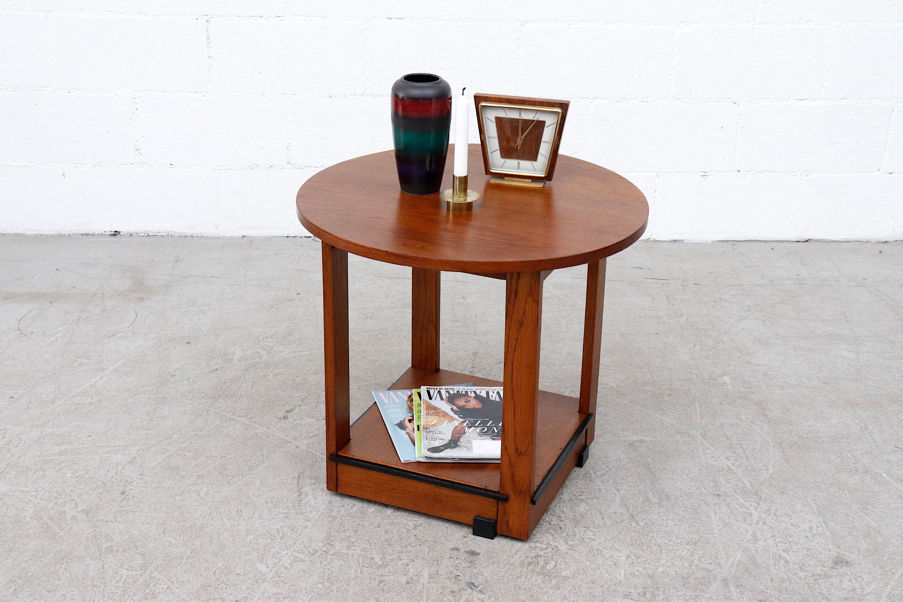 Amsterdam school oak side table with round top, square frame and ebony stained wood detail. In original condition with wear consistent with it's age and use.