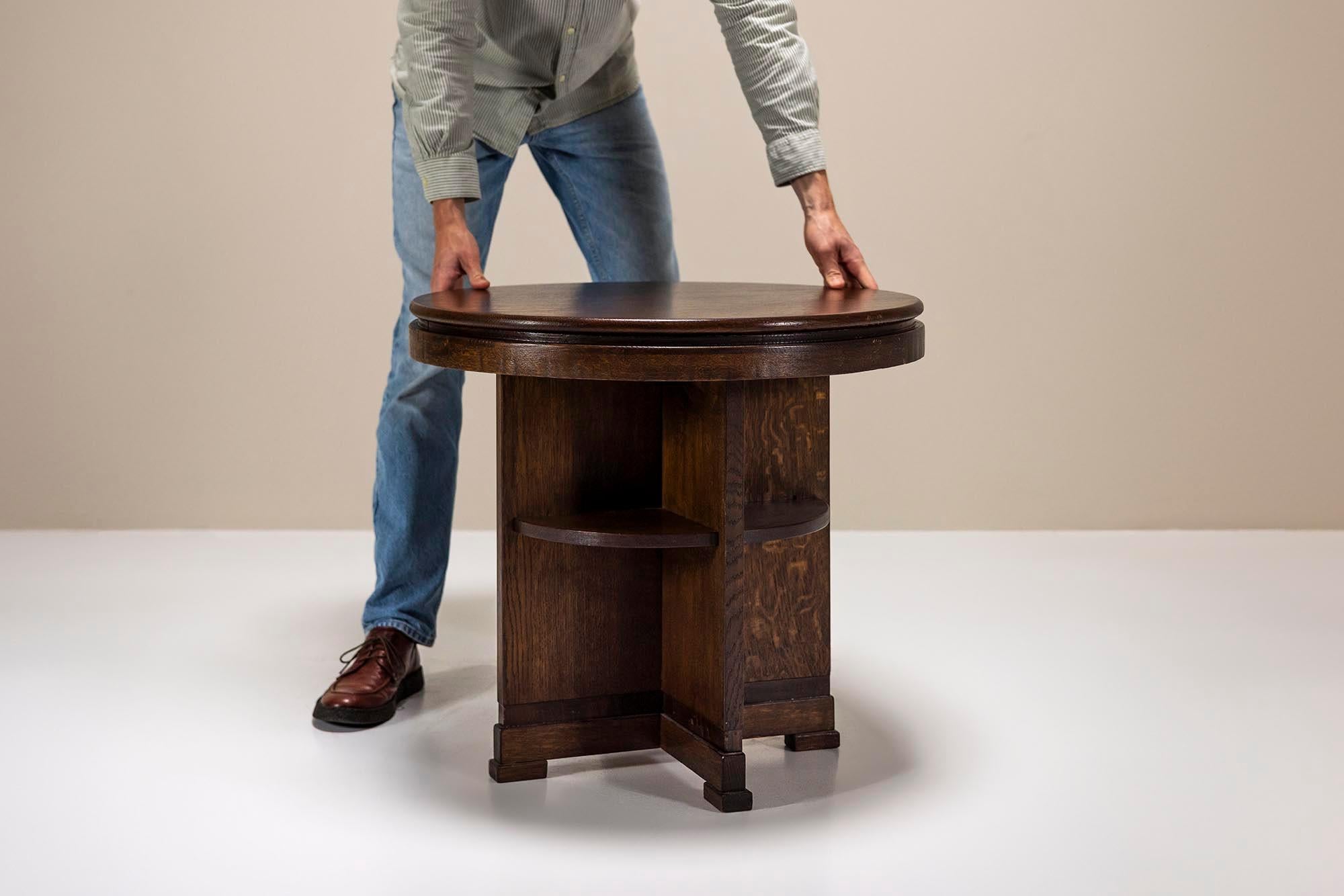 This round side table showcases the bold design of the Amsterdam School, a Dutch architectural and design movement celebrated for its expressive forms and craftsmanship. Dark-stained oak brings out rich wood grain, creating a warm, deep patina that