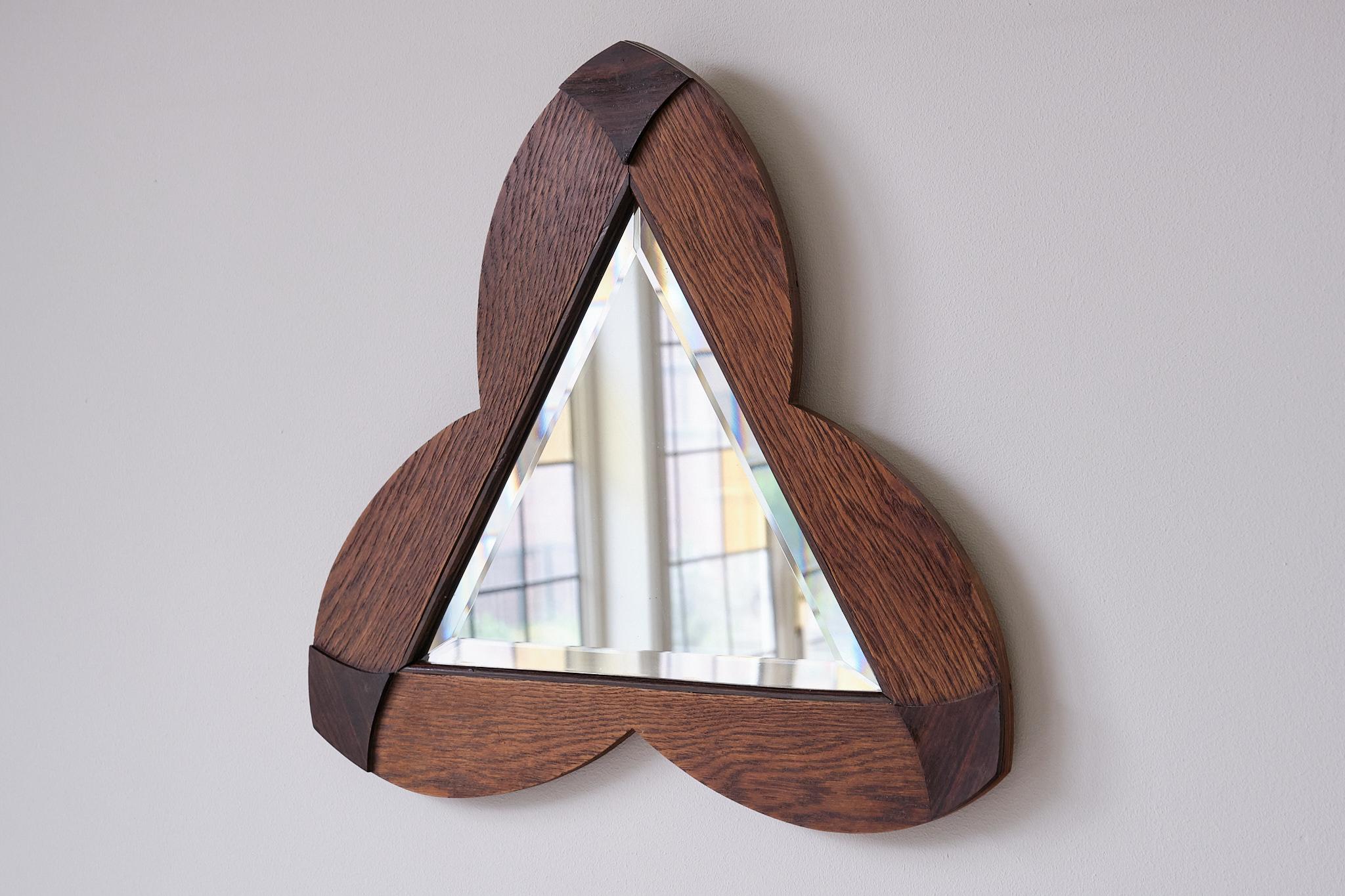 This rare wall mirror was produced in the Netherlands in the 1930s. The shape, material, and craftsmanship of the piece are exemplary of the Amsterdam School movement. Originating in the Dutch capital in the 1920s, this unique style is rooted in