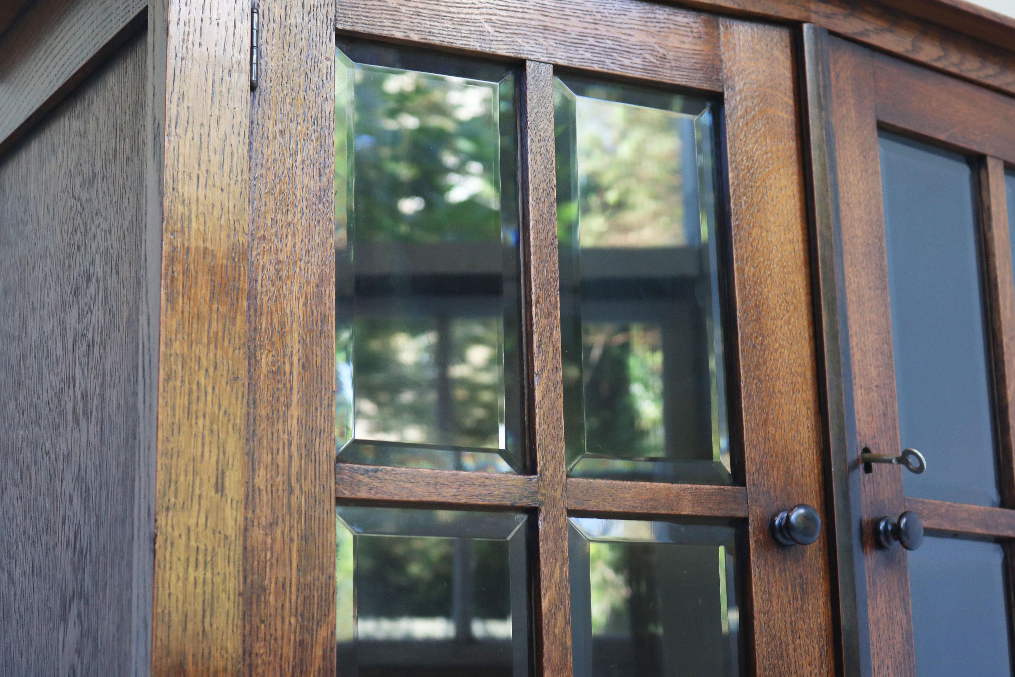 Hand-Carved Amsterdams school tea cabinet / display cabinet European oak beveled glass 1920 For Sale