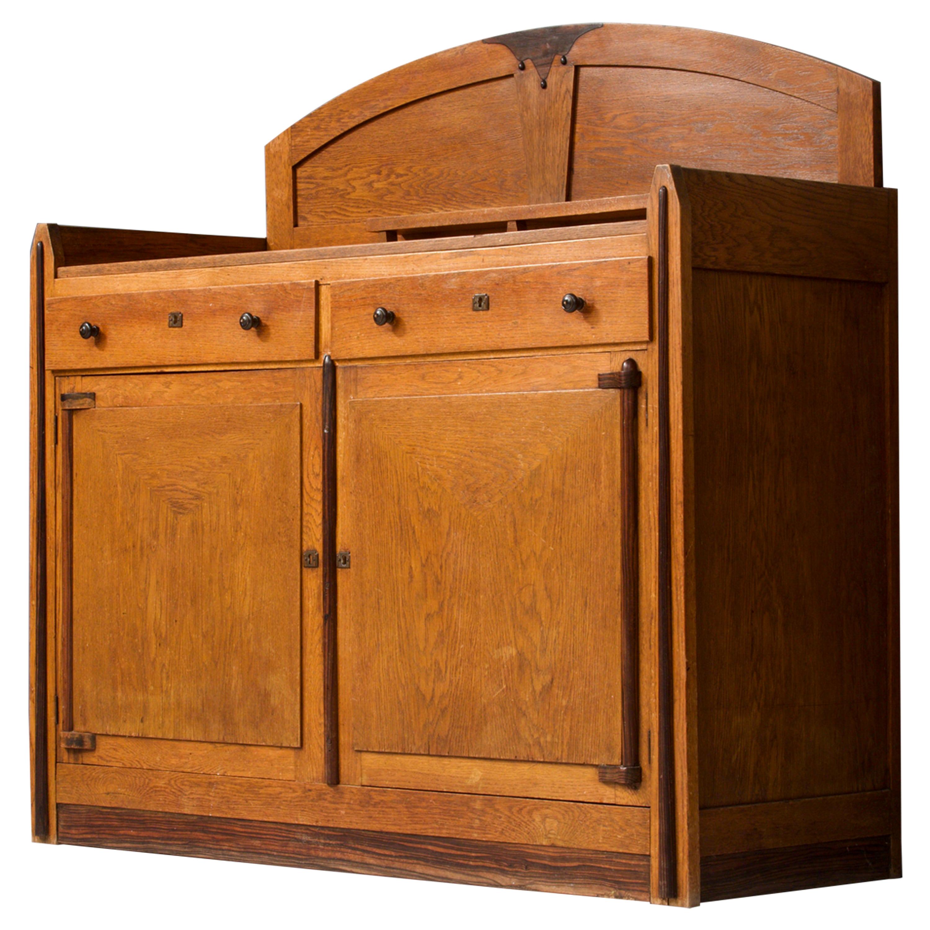 Very well preserved Art Deco bar cabinet from the late 1920s. This high cabinet has a lot of typical details from the Dutch Amsterdamse School Period, that reflects the architectural style that was very dominant at that time. Lots of houses here in