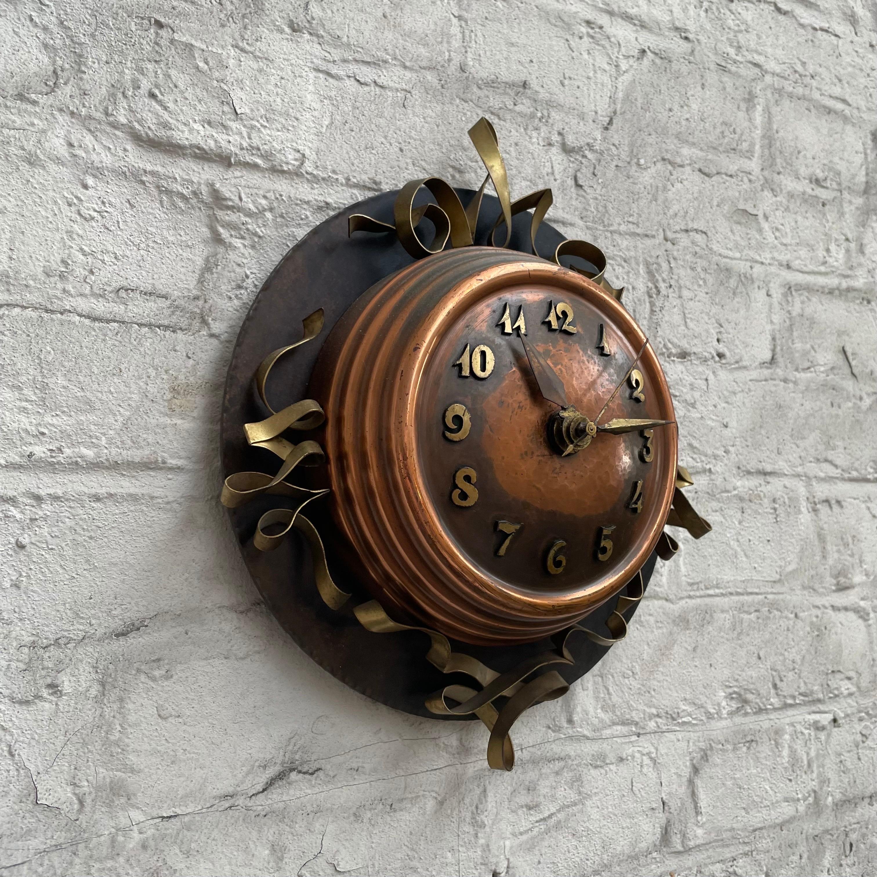 Amsterdamse School Art Deco Wall Clock, The Netherlands, 1930s.

Elegant and stylish wall clock in a distinct 'Amsterdamse School' or art deco style. A very decorative design with great tones and curly shapes. The hand hammered middle part in
