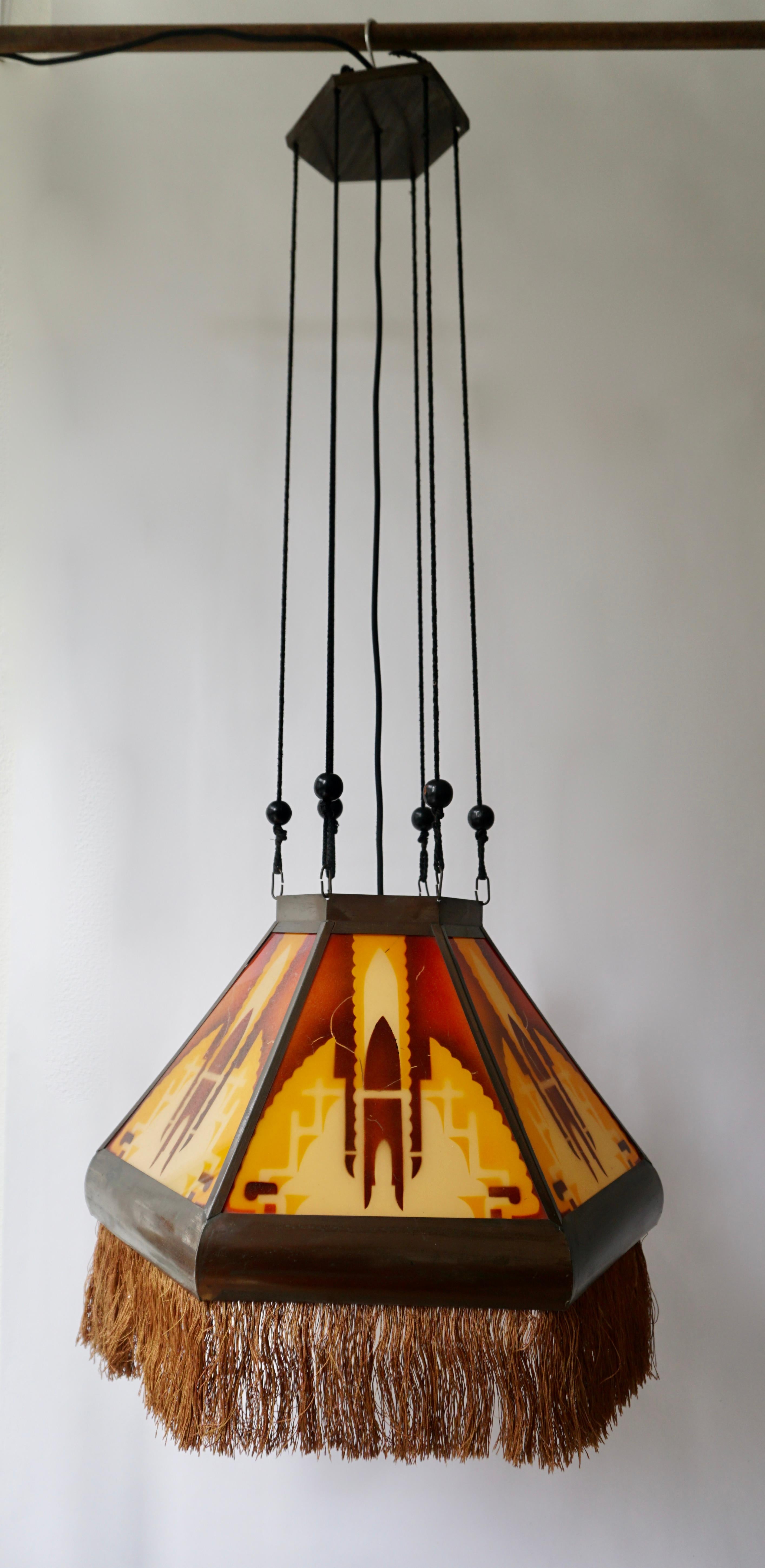 ‘Amsterdamse School’ glass Art Deco pedant light, manufactured in the 1920s in the Netherlands. Very subtle Dutch design pendant in hexagon shape featuring 6 glass panels and beautiful colored glasses in a brass armature, with an orange-colored
