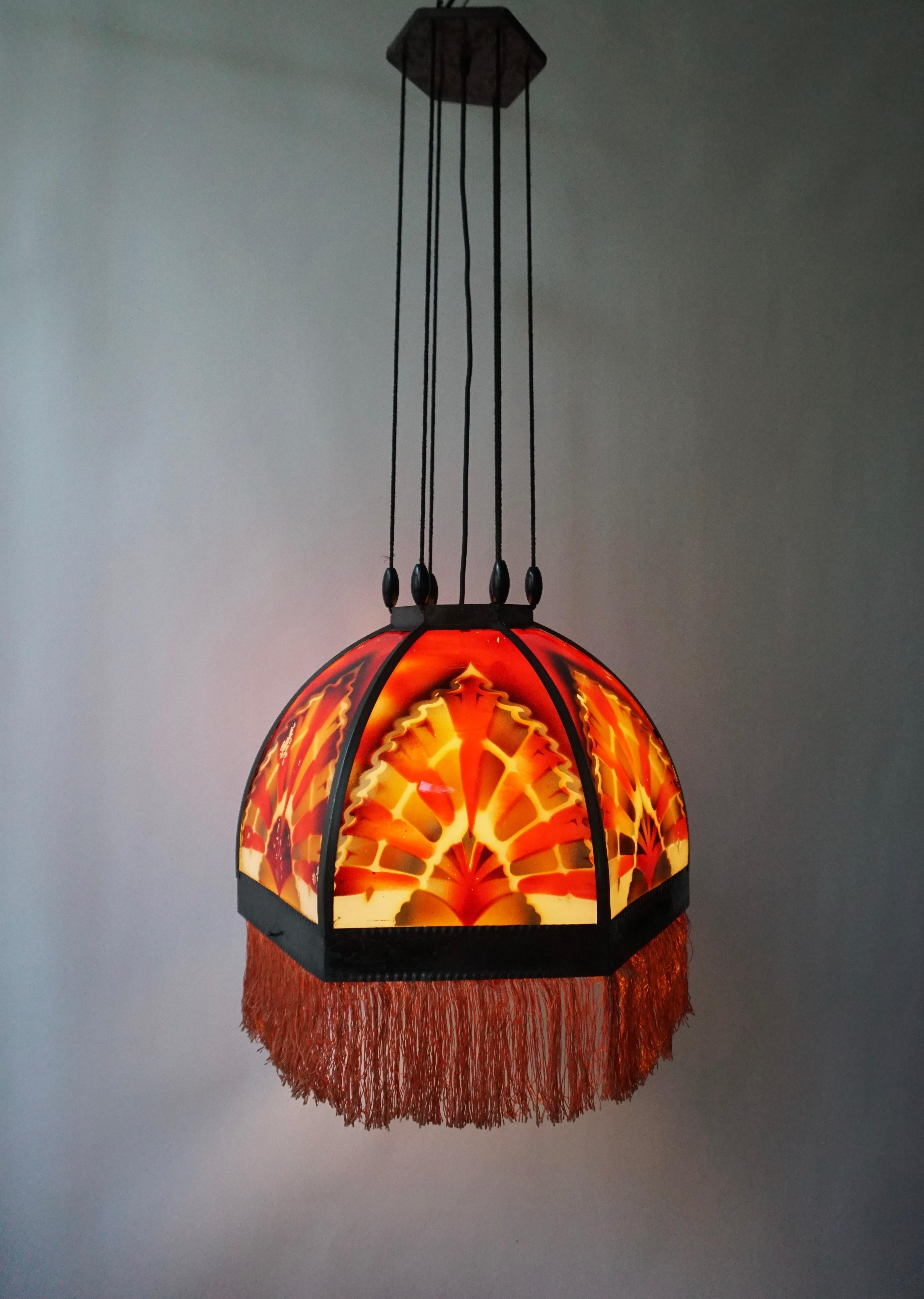 Beautiful ‘Amsterdamse School’ glass Art Deco pedant light, manufactured in the 1920s in the Netherlands. Very subtle Dutch design pendant in hexagon shape featuring 6 glass panels and beautiful colored glasses in a brass armature, with a