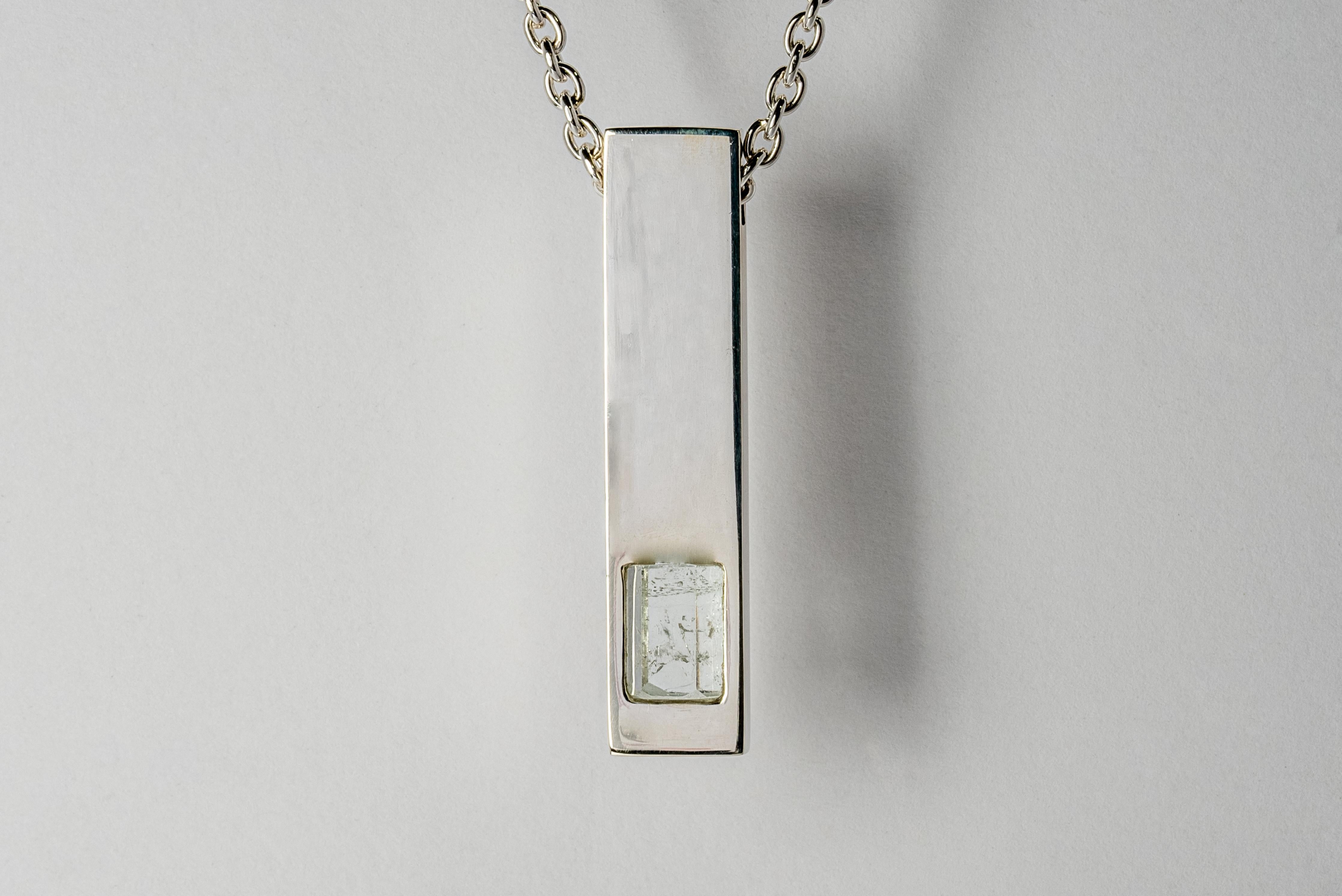 Pendant necklace in the shape of cuboid made in polished sterling silver and a slab of rough aquamarine. The Amulet series seeks to encapsulate the energy of a mineral element(s). This family is a branch from the Talisman family and seeks to further
