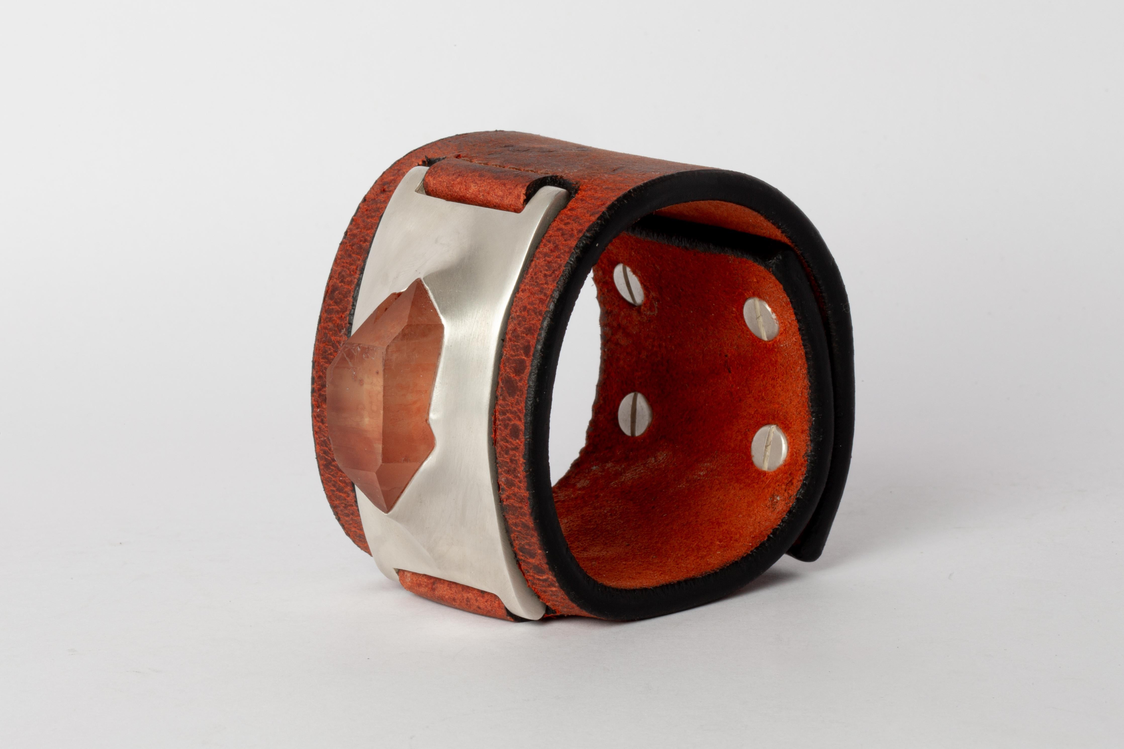 Bracelet in brass, iron quartz, and orange kudu waxy leather. Brass substrate is electroplated with silver and then dipped into acid to create the subtly destroyed surface. This item is made with a naturally occurring element and will vary from the