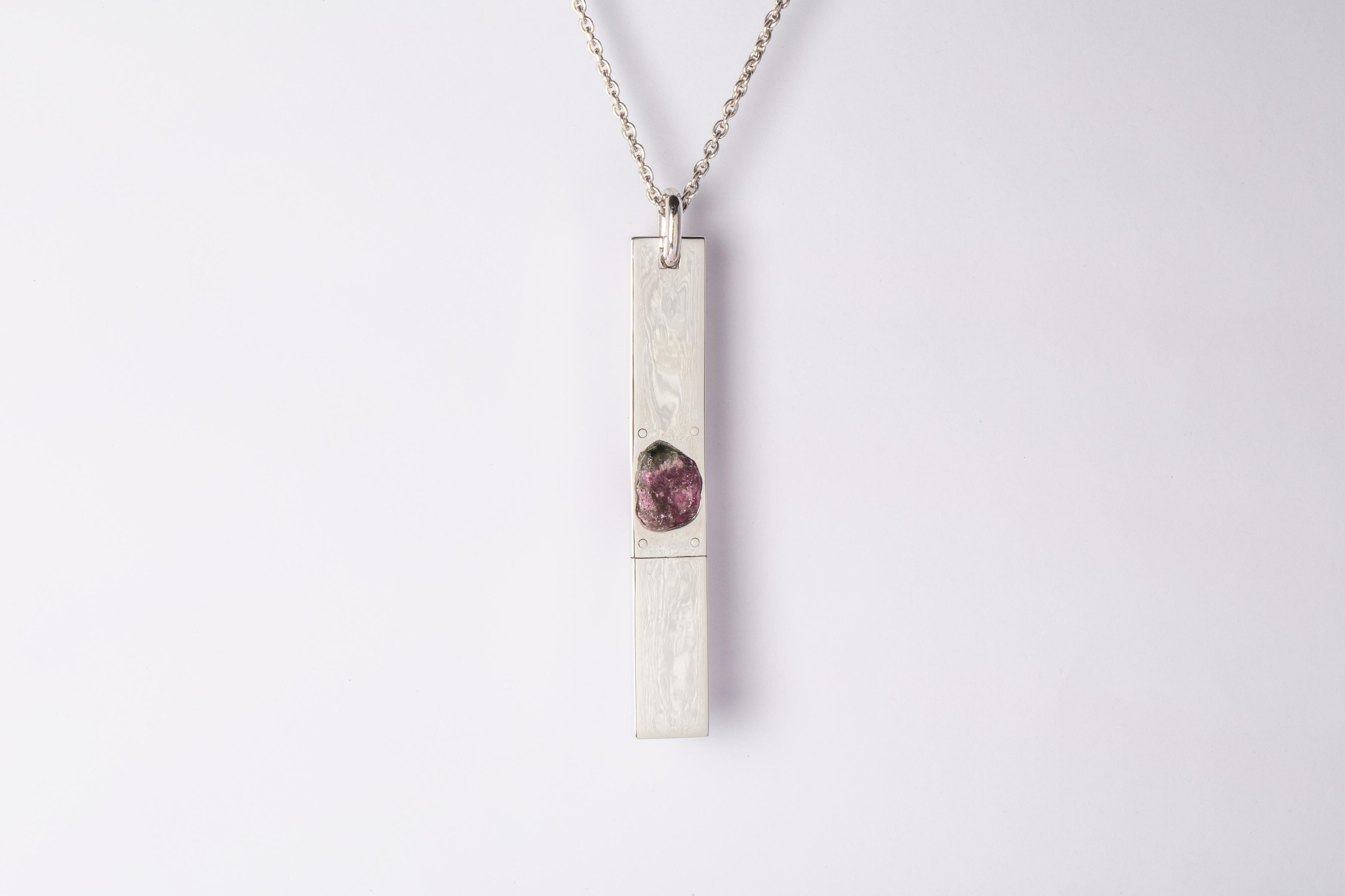 Necklace made in polished sterling silver and a rough of elbaite, a green-pink tourmaline color. The Amulet series seeks to encapsulate the energy of a mineral element(s). This family is a branch from the Talisman family and seeks to further explore