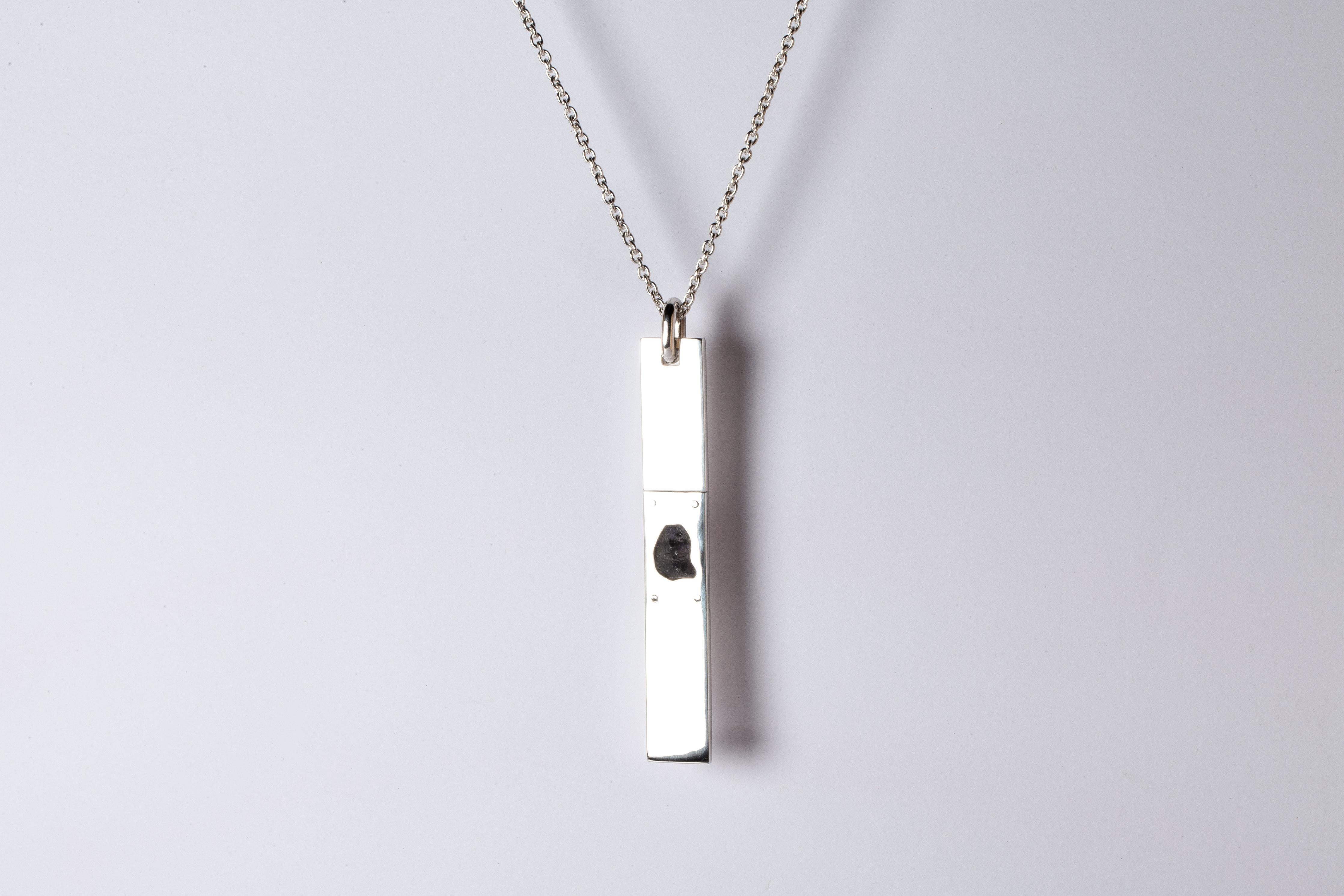 Pendant necklace in polished sterling silver and a slab of rough iolite. The Amulet series seeks to encapsulate the energy of a mineral element(s). This family is a branch from the Talisman family and seeks to further explore the creation of magical