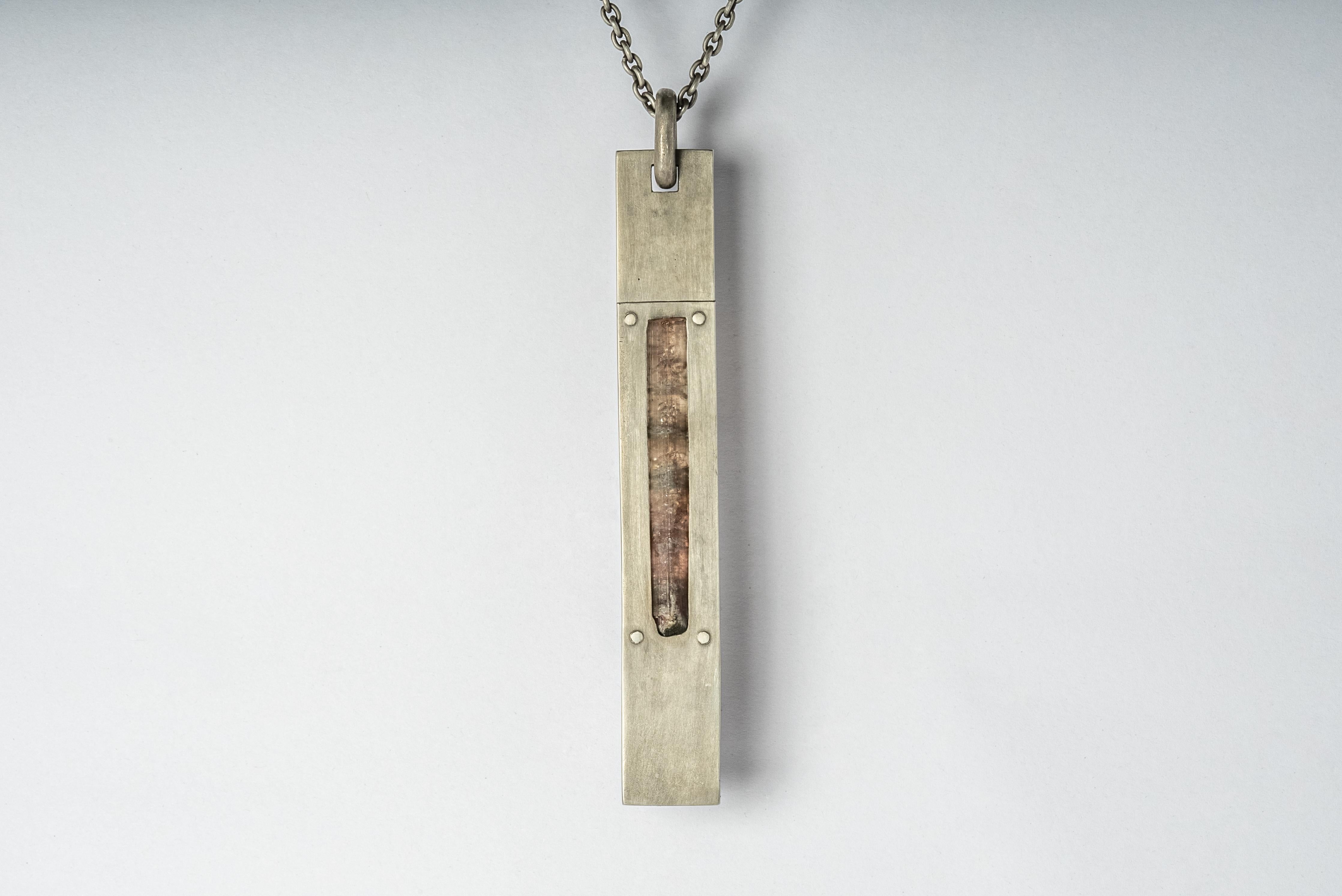 Necklace in dirty sterling silver and a slab of rubellite. Sterling silver, dipped in acid to create a subdued surface. The Amulet series seeks to encapsulate the energy of a mineral element(s). This family is a branch from the Talisman family and