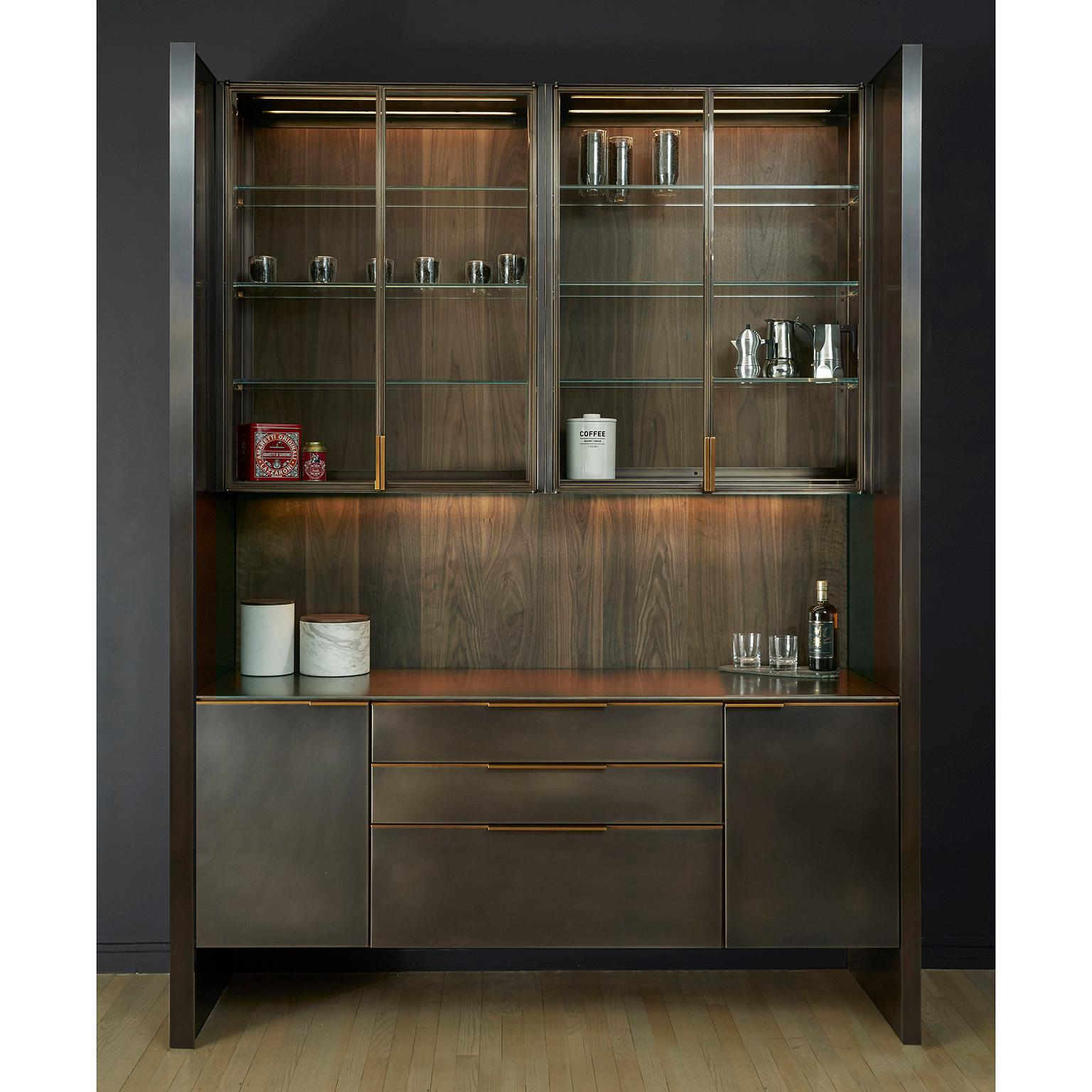A bar system that blends individual functionality with Minimalist detailing. The interior cabinetry is fabricated from solid wood and handcut veneers offering the highest quality traditional woodworking techniques. The hand blackened stainless steel