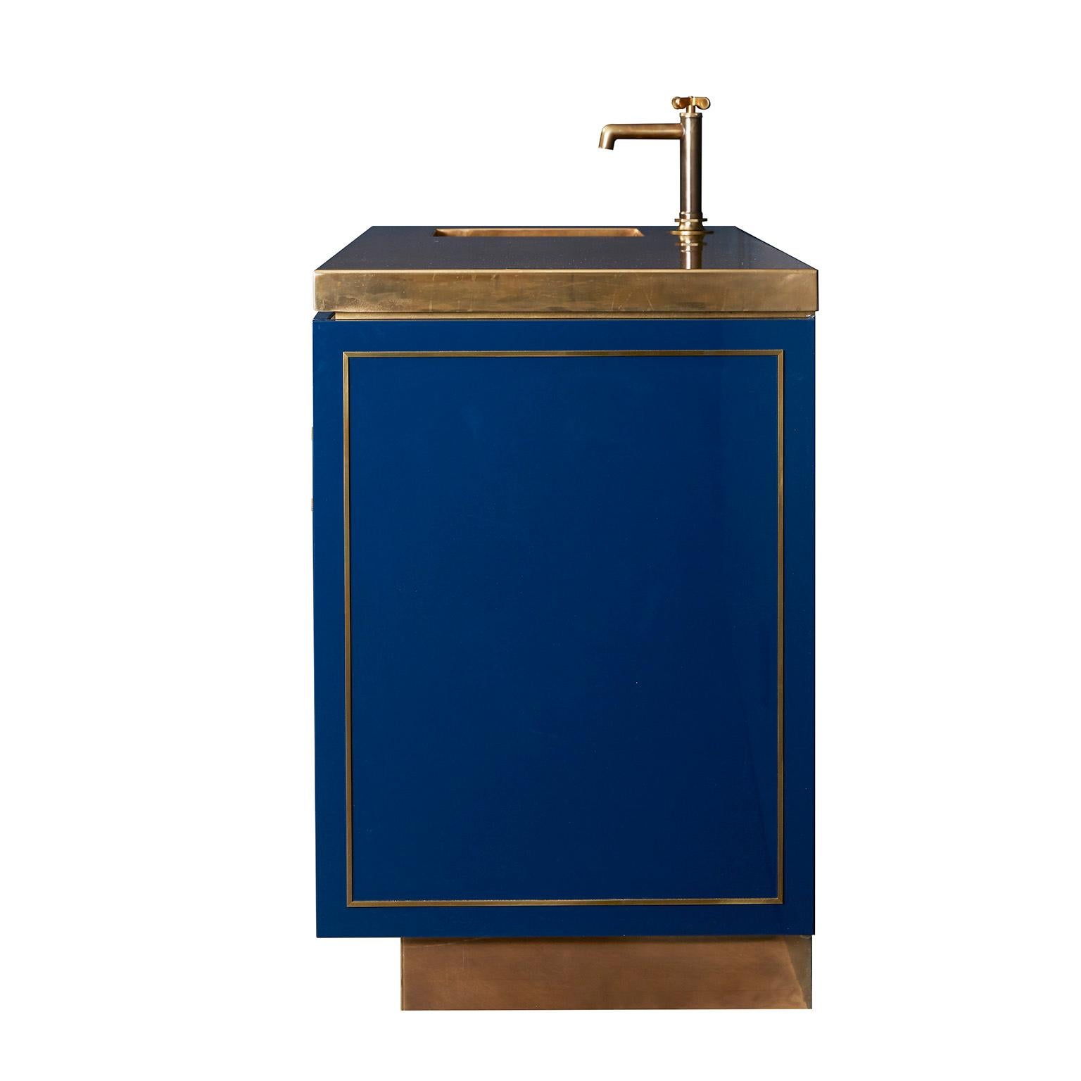 Hand-polished lacquered cabinet doors and drawer faces inlayed with buffed brass and integral pulls create a modern, tailored statement. The composition of the lower cabinet is set off against a polished and patinated brass counter, which brings a
