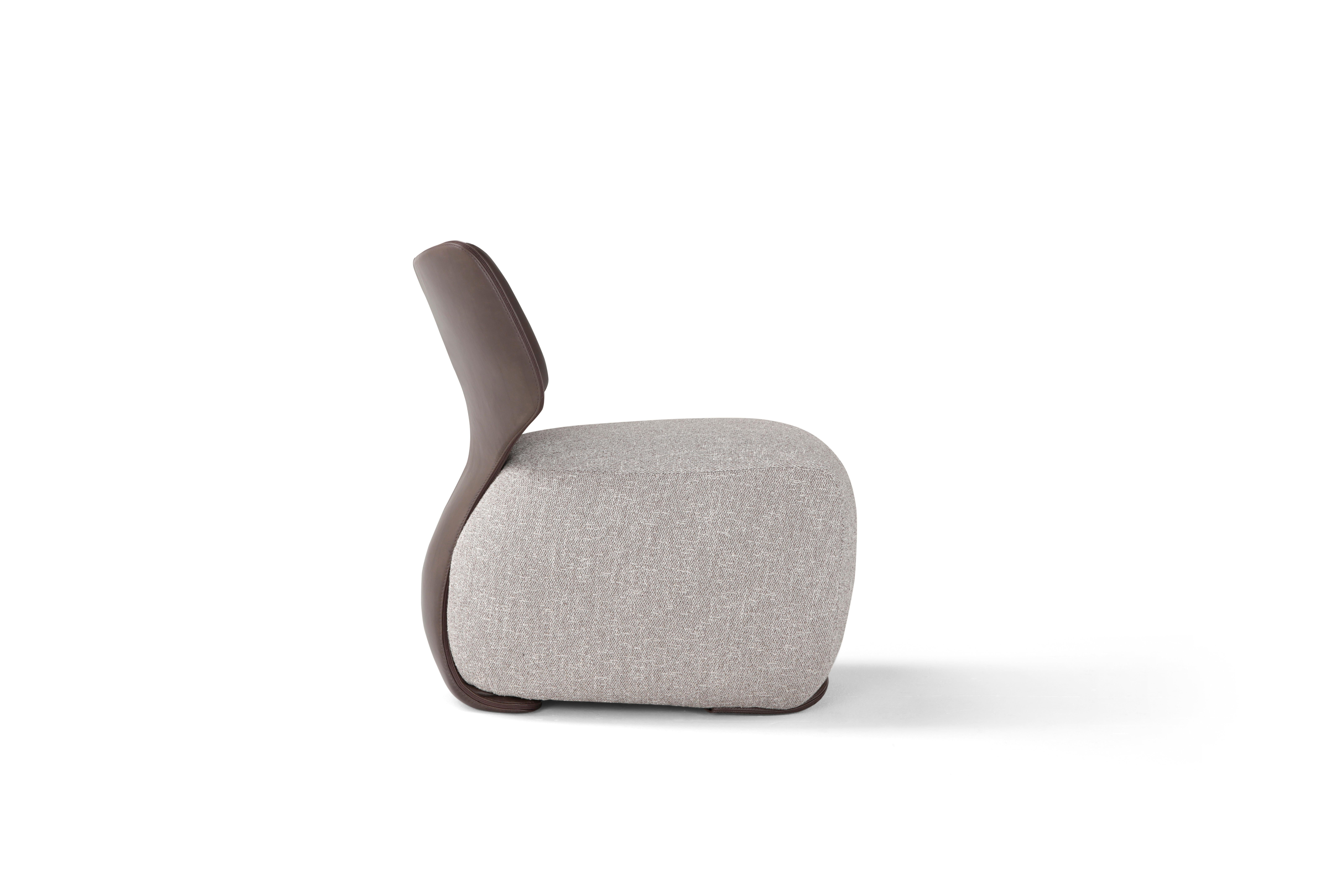 Noa armchair in grey upholstery and brown leather.