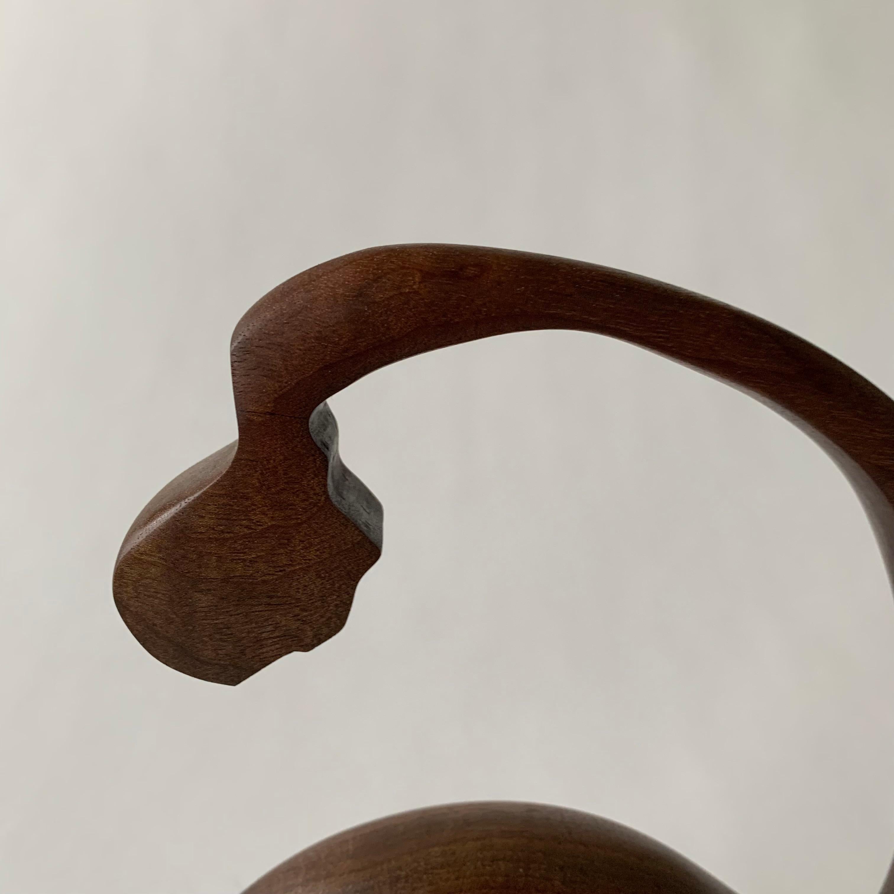 Walnut is one of the most beautiful of American hardwoods. Known for its fine-yet-open grain, unique patterns, and bold dark color. Hand carved, shaped, and polished, this wood melds into beautiful symmetry in this abstract sculpture. The natural
