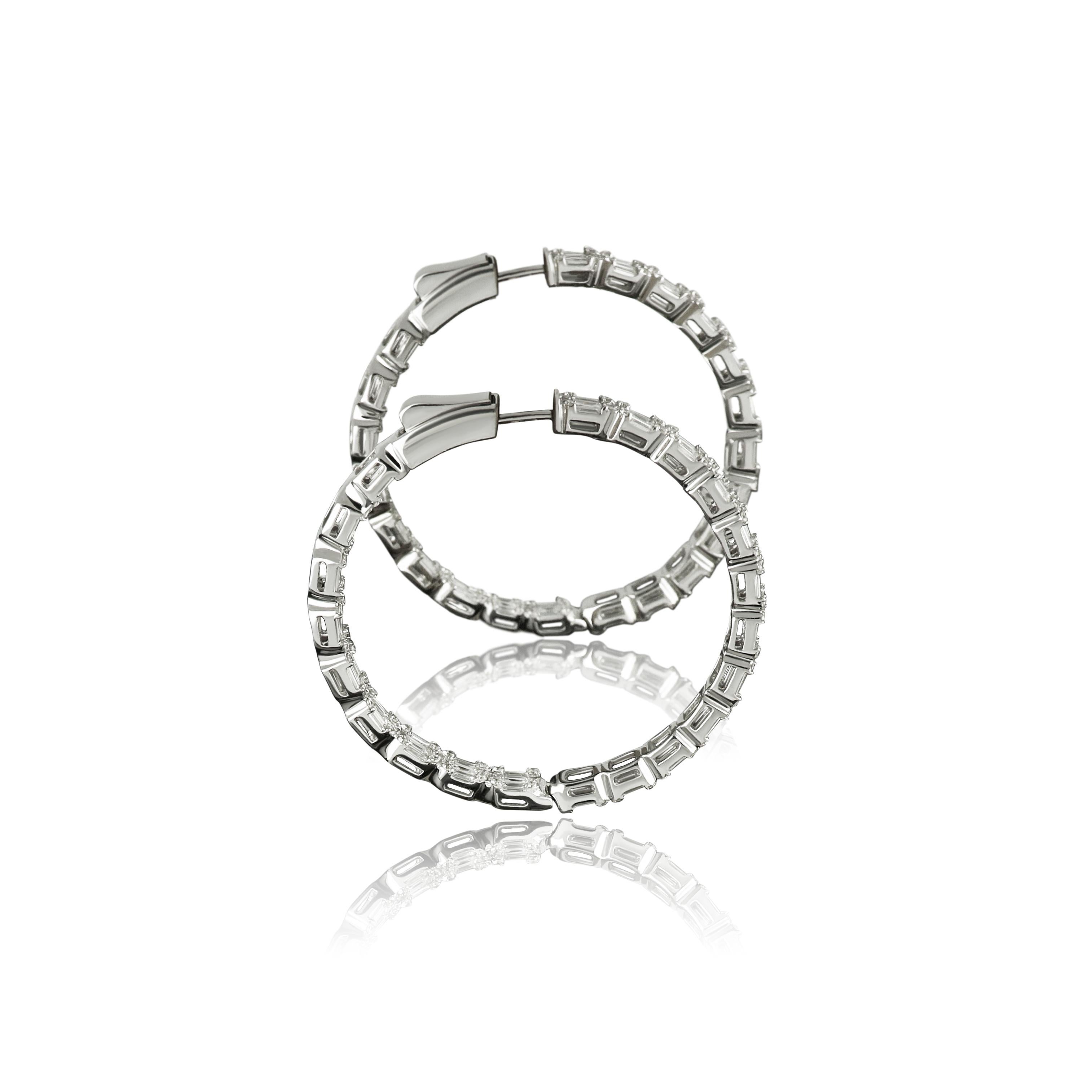 A fascinating demonstration of modern design, Amwaj 18 karat white gold diamond hoop earrings feature smooth row of diamonds that loops gracefully around the ear. Baguette and round cut diamonds are subtly joined to create a shining circle of