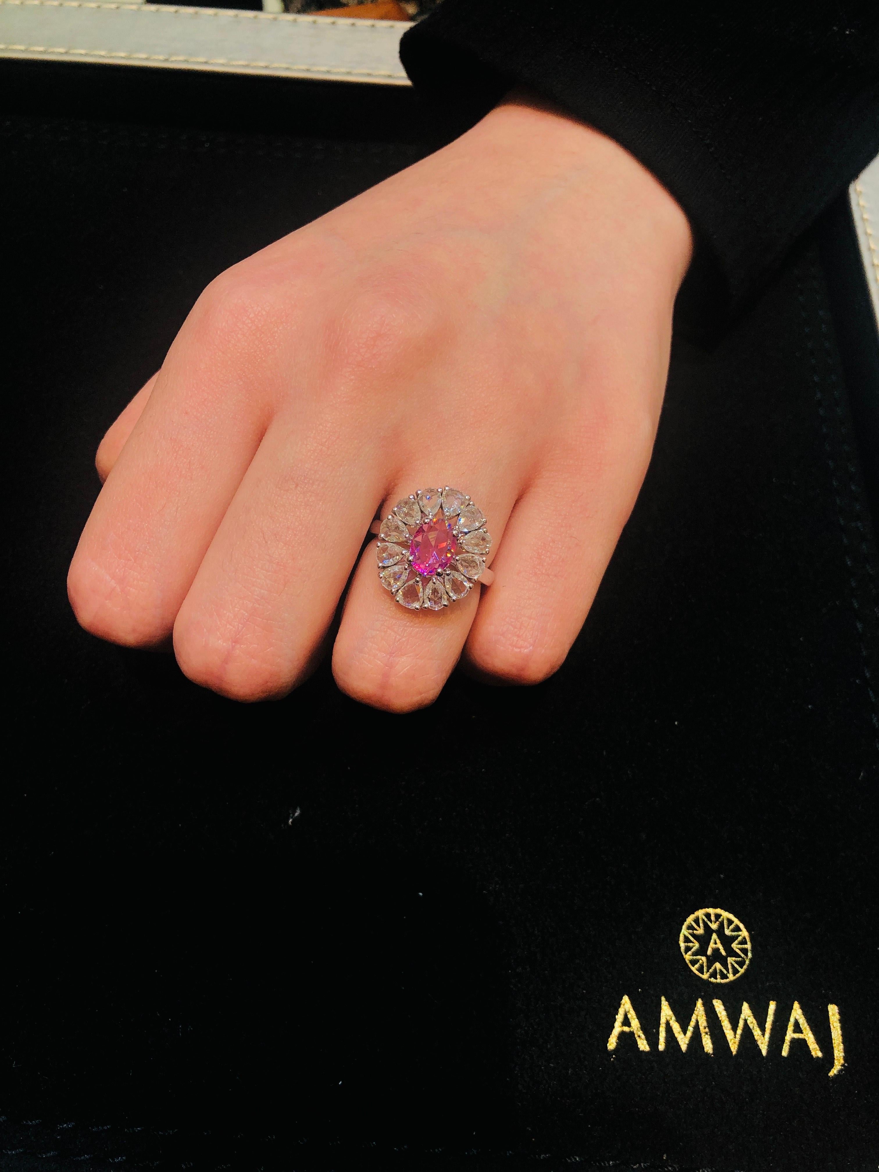 Délicate et féminine bague Amwaj en or blanc 18 carats avec diamants. L'envoûtant saphir rose central, entouré de diamants taillés en poire et en rose, qui donnent une touche de rêve et d'étincelle à cet article qui brille par sa beauté, vous
