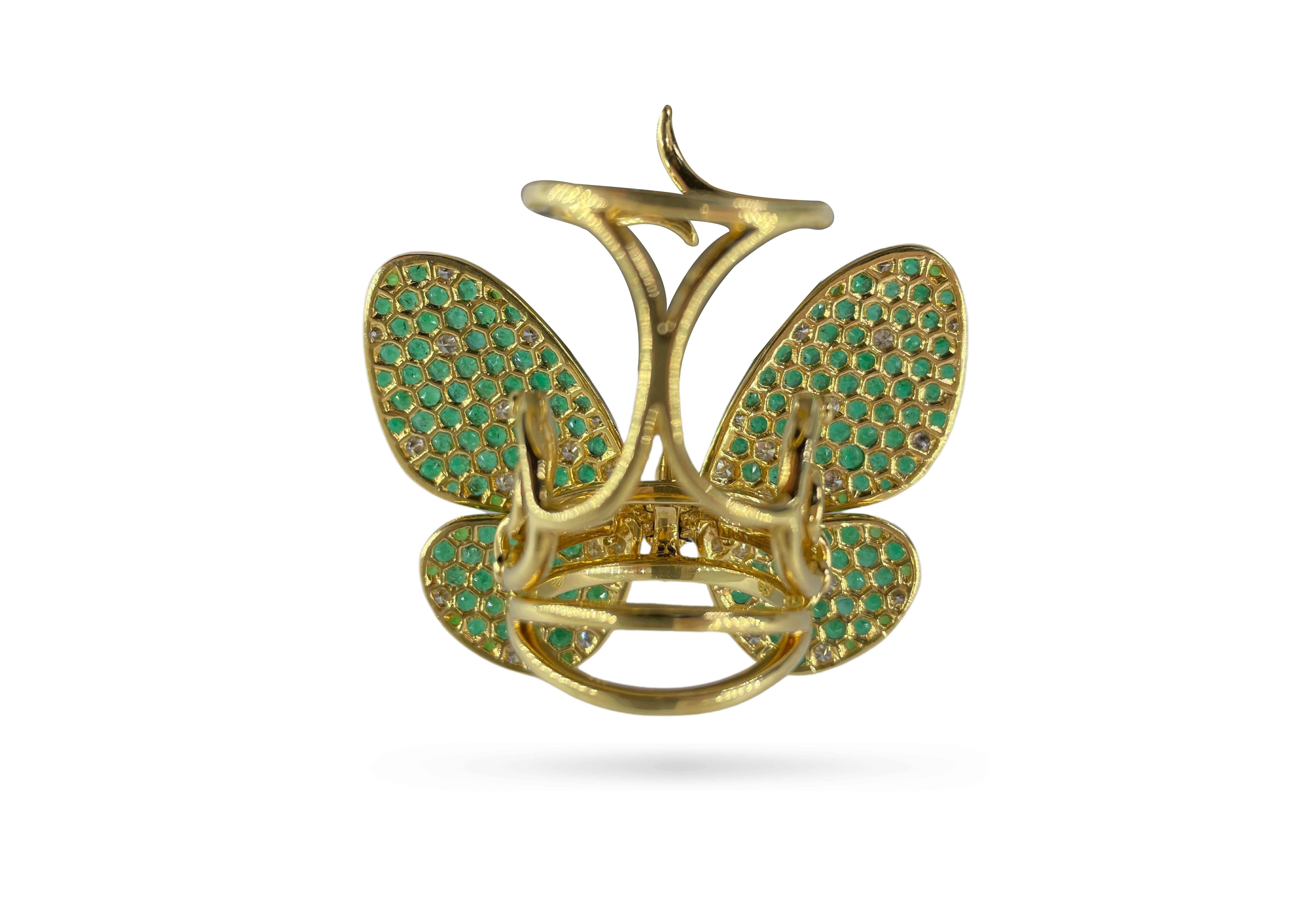 Featuring a playful butterfly motif set with round cut diamonds and green sapphires, Amwaj charming ring captures the beauty of butterfly wings created in shining rows of diamonds and sapphires set in 18 karat yellow gold, each of stone has been