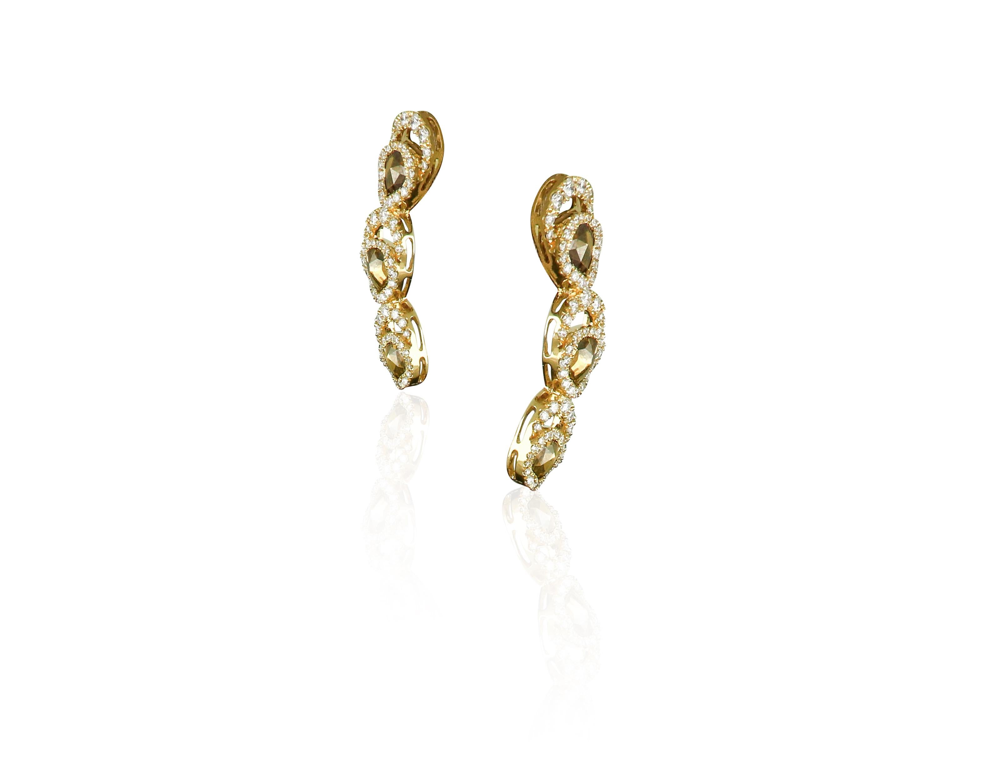 Combining exceptional artistry with extraordinary craftsmanship. Amwaj beautifully articulated inspired by palm tree earrings in 18 karat yellow gold feature mesmerizing brown diamonds swirls that exude brilliance as they descend dramatically