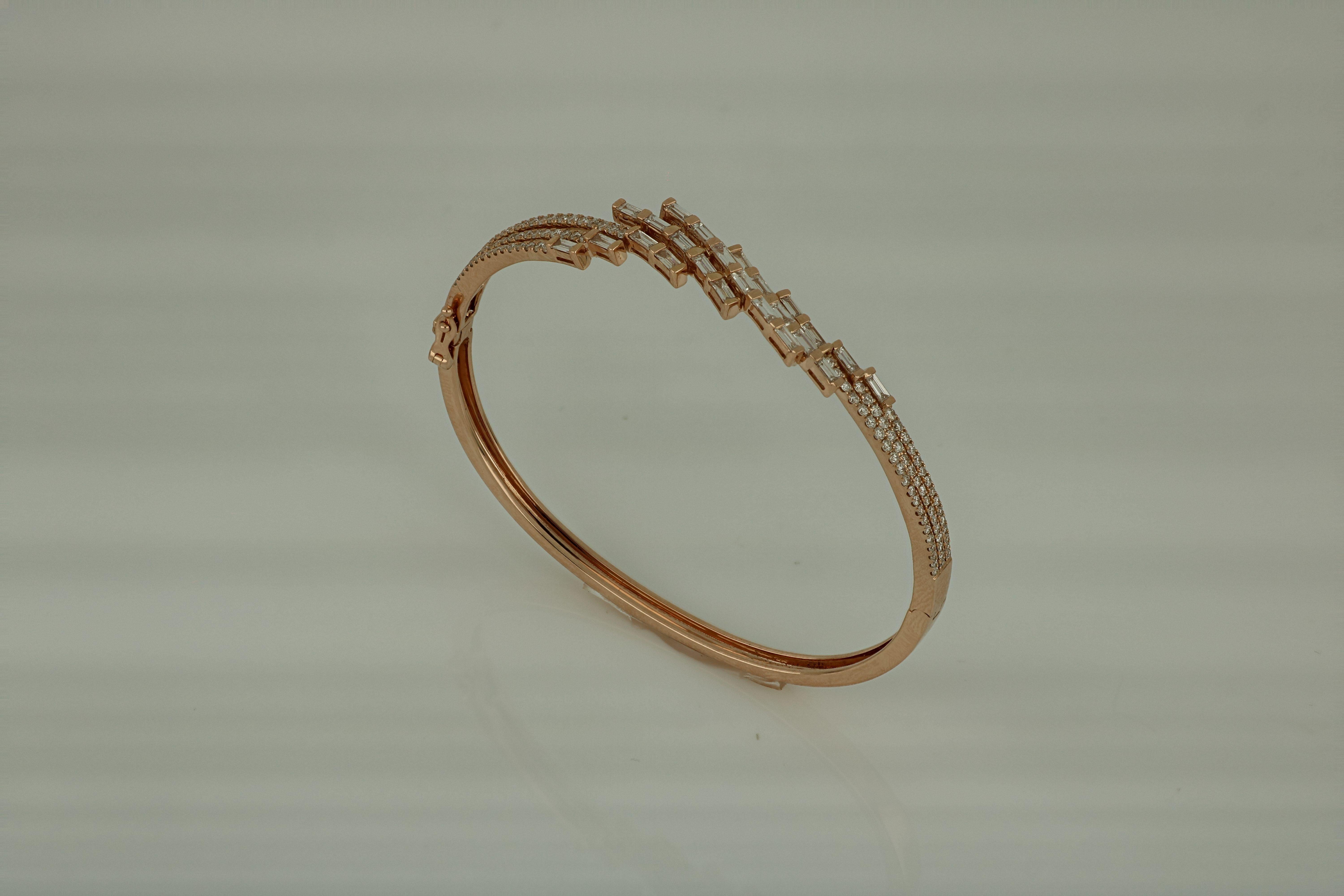 Emerald cut Diamonds, seemingly set at random angles to form an artfully abstract web of stones in this 18 Karat rose gold bangle .
Diamonds (Total Carat Weight:  1.68 CT )
Diamond clarity: VS . SI / H Color
18 Karat gold ( total weight of gold :