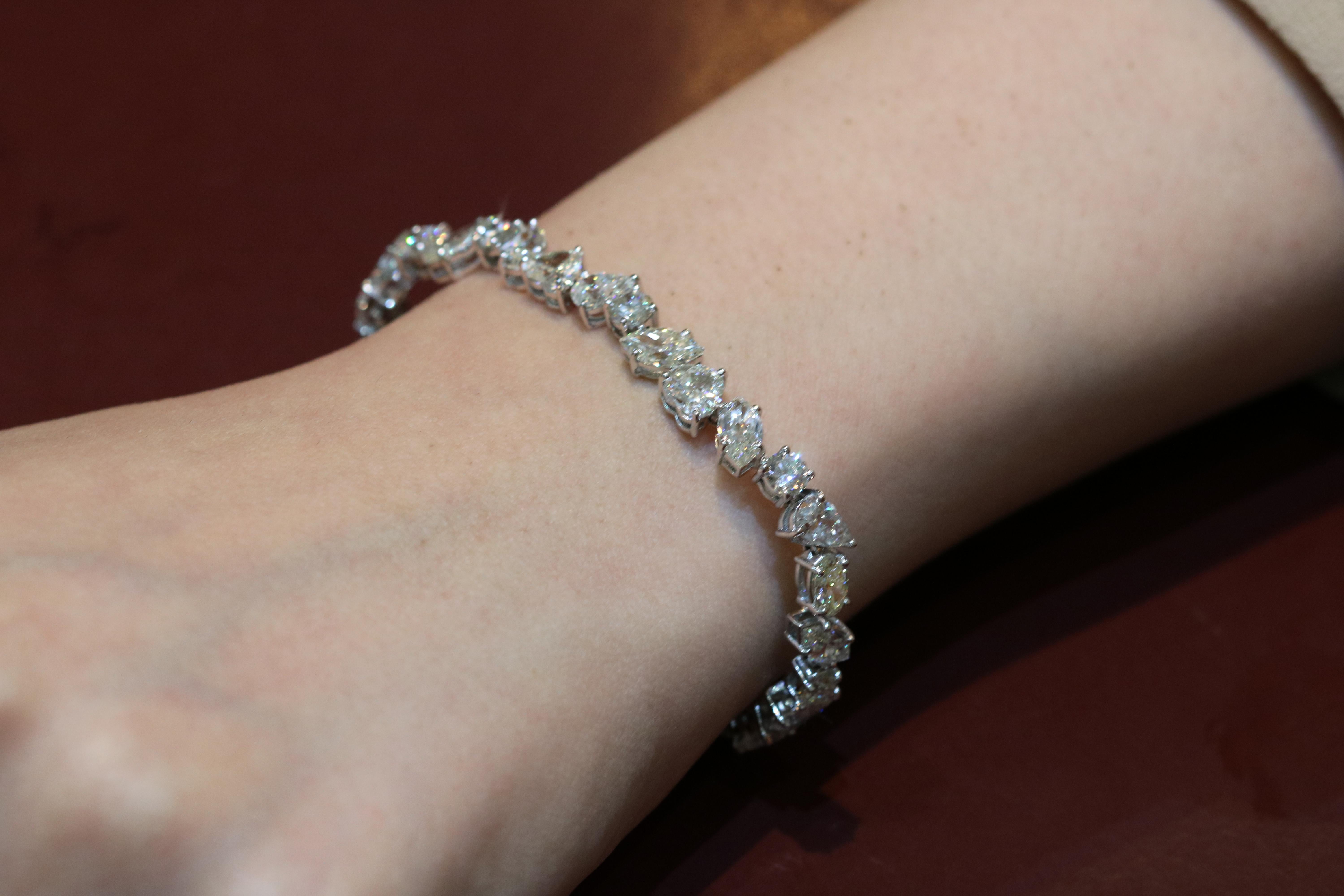 This round, heart, oval, and marquise cut diamond bracelet is an ultimate expression of precious beauty. The multi-shape 18 Karat white gold bracelet allows the radiant brilliance of a classic diamond to shine through, making it an enchanting and