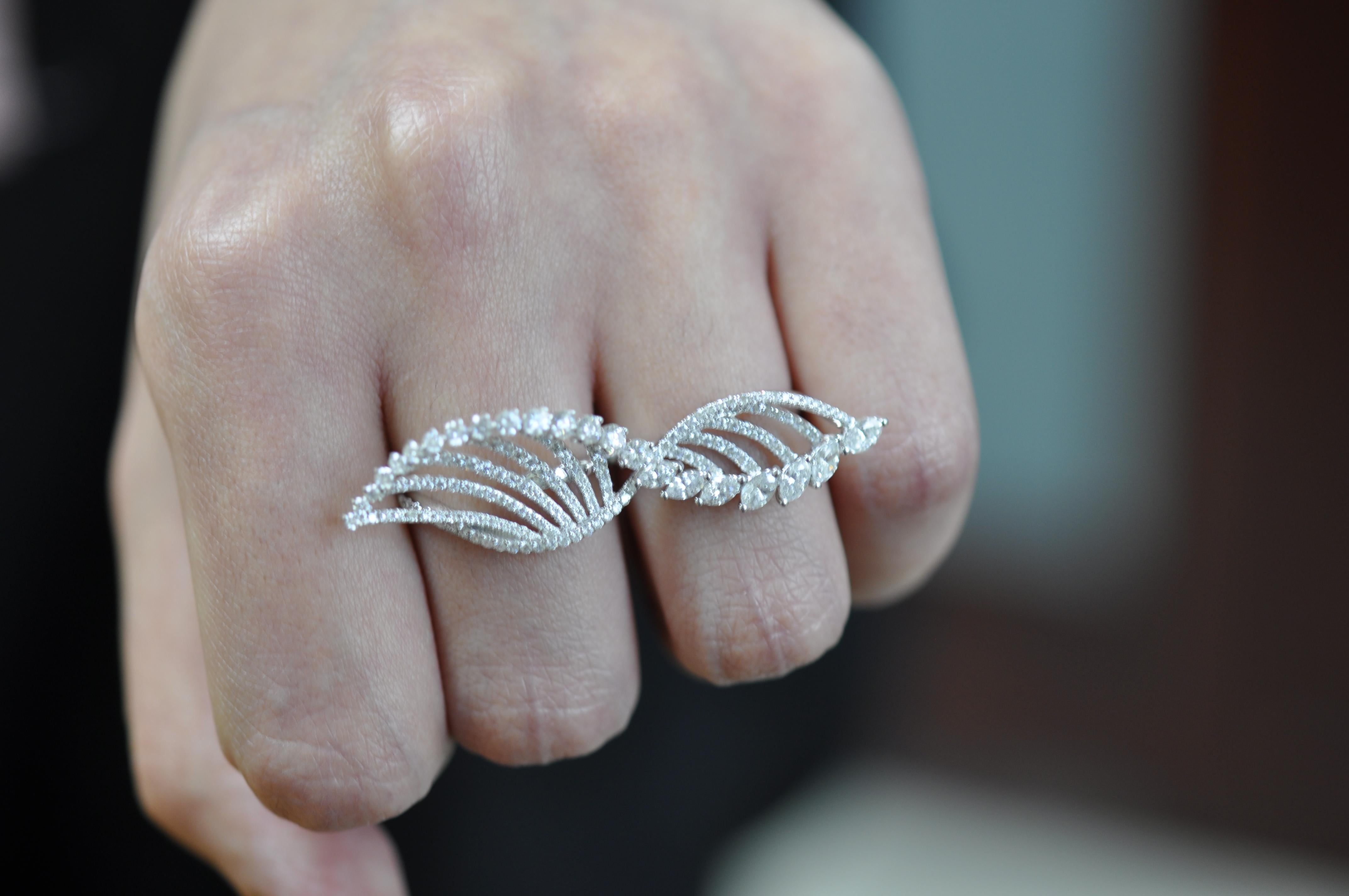 Questo anello in oro bianco con diamanti rotondi e a forma di Marquise di Amwaj jewelry, eseguito a forma di ali, completerà in modo ideale il tuo look da sera La superficie delle ali è completamente coperta da un abito di diamanti brillanti. Questo