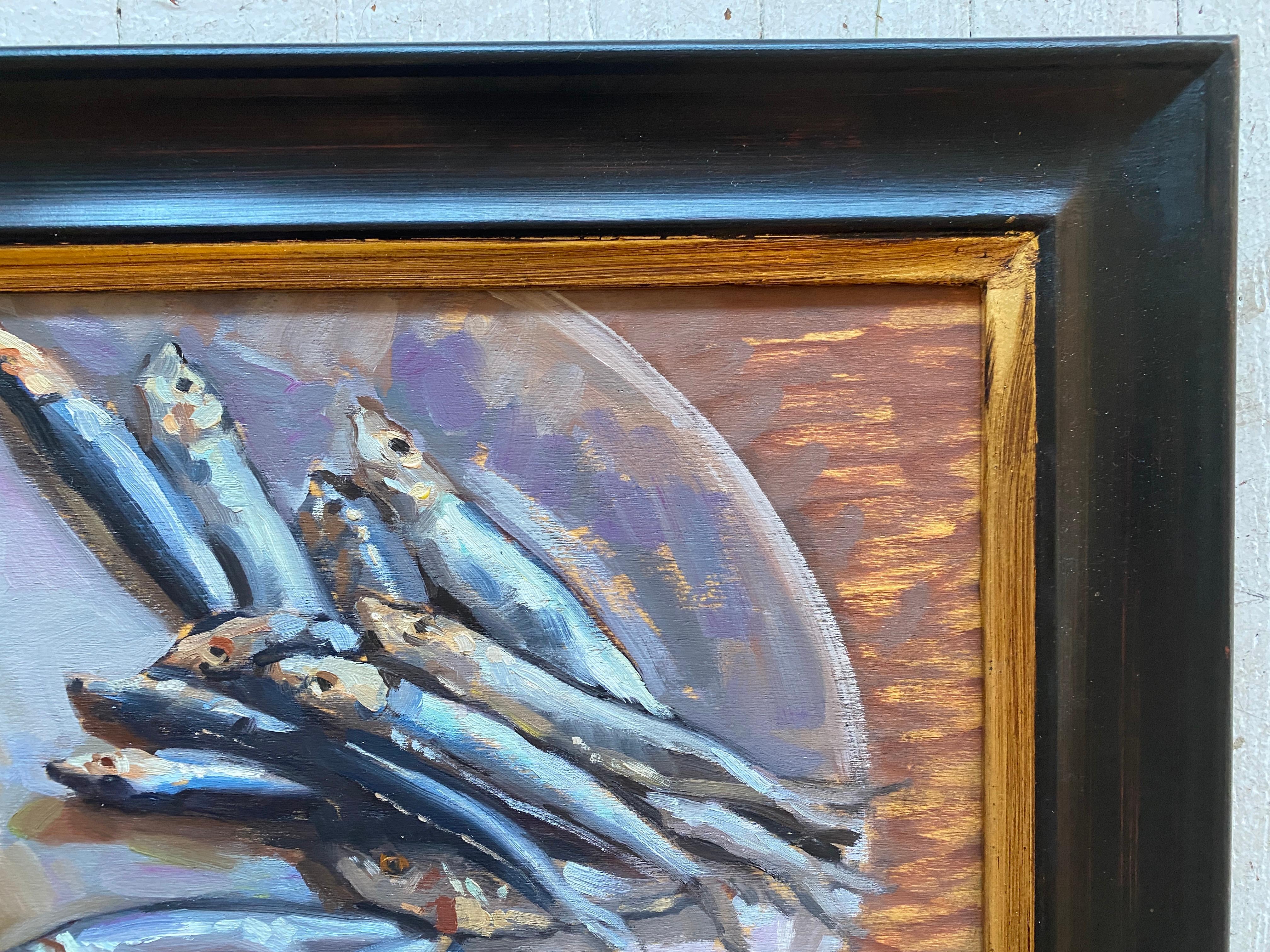 An oil painting of sardines on a round white plate. Painted from direct observation, using classical academic painting methods. Small colorful brushstrokes make up scaly metallic fishes, which glisten atop a simple white plate. 

Framed in a