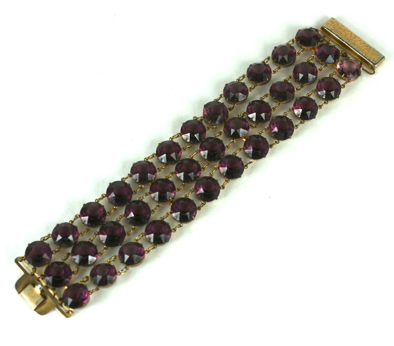 Amythest Crystal Link Bracelet from the 1950's. Made in the Deco style with a gilt clasp. 3 large rows of crystals are linked and form a wide flexible bracelet. 1950's USA. 
7.25