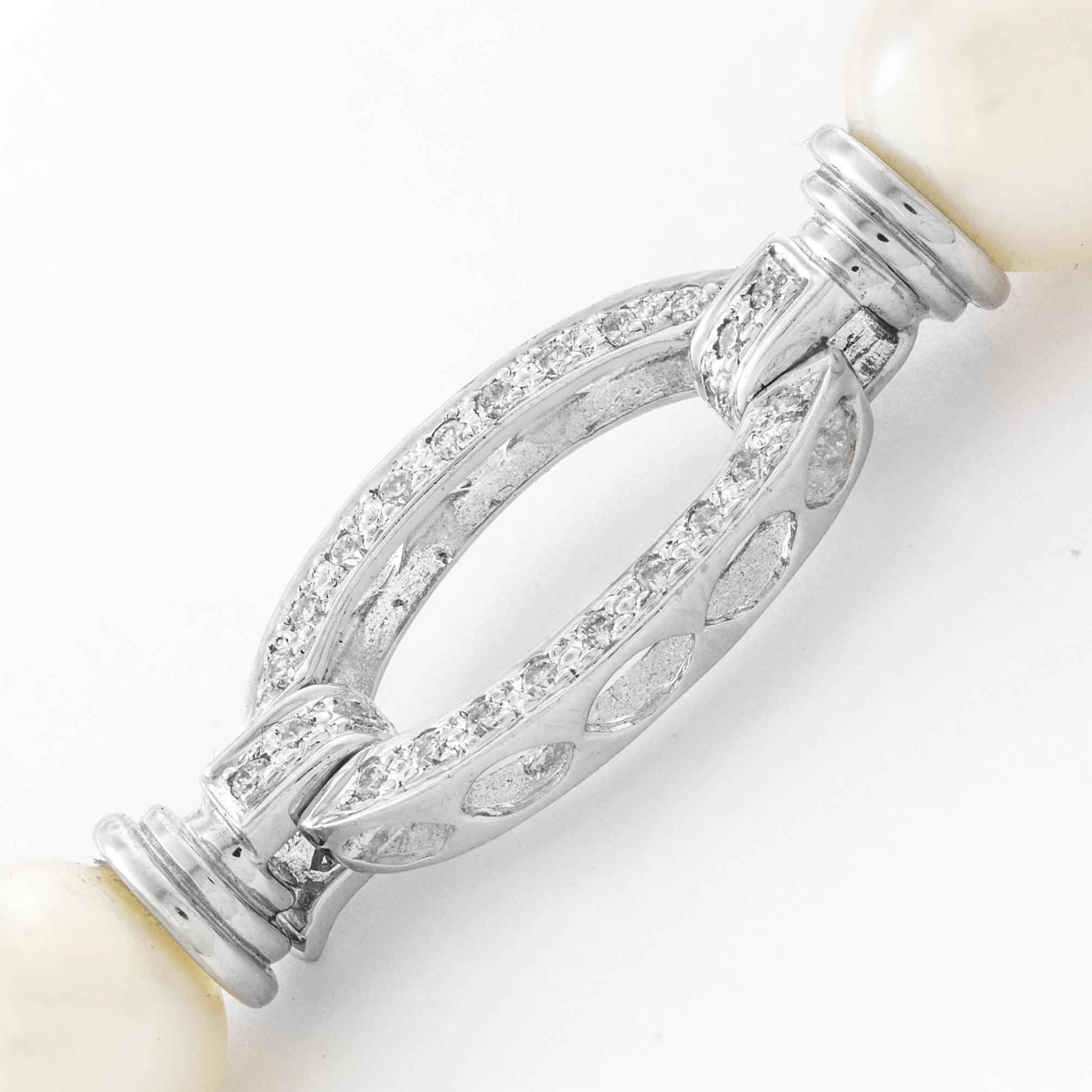 An 18 carat diamond-set oval frame clasp, set on one side with round brilliant-cut diamonds weighing 0.22 carats, all in 18 carat white gold, hallmarked 18ct gold,  London, bearing  the 'MGD' sponsor mark, measuring approximately 2.3 x 1.1cm.

This