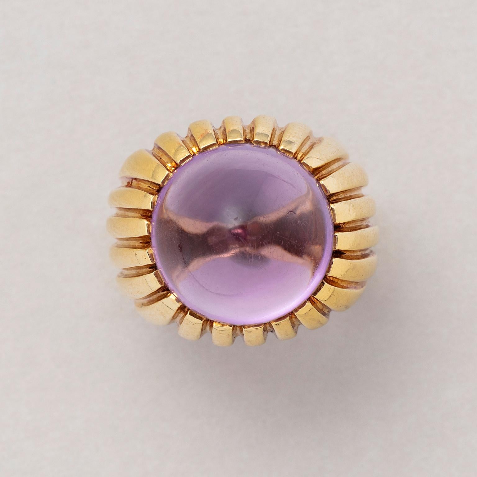An 18 carat yellow gold verticvally ribbed ring set with a round, pointed cabochon cut amethyst. Signed: Fred, Paris, circa 1980.

weight: 14.45 grams
size: 16.25 mm / 5 1/2 US
width: 5.5 – 12 mm