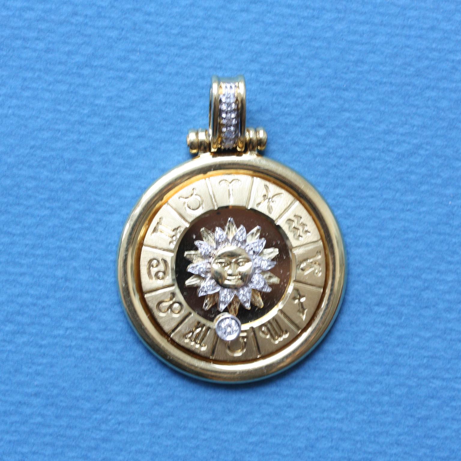 An exceptional 18 carat yellow gold zodiac pendant, all twelve zodiacs are presented in a twelve sided border, with in the center of the pendant the sun with rays of diamond and rays of gold, a diamond marker rotates from the border (app. 0.1 carat)