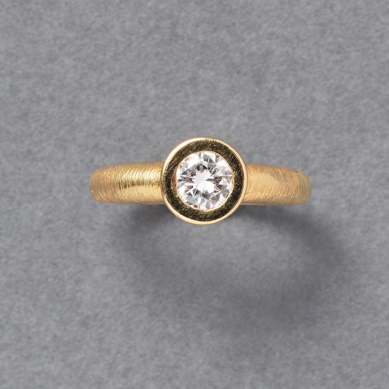 Anillo solitario de oro amarillo de 18 quilates, finamente labrado, engastado con un diamante talla brillante (aprox. 0,75 quilates, E-F, Vs) en un bisel pulido y cerrado, francés.

peso: 9.9 g
talla: 18,5 mm / 8 1/2 US
anchura: 2,2 - 8,5 mm
